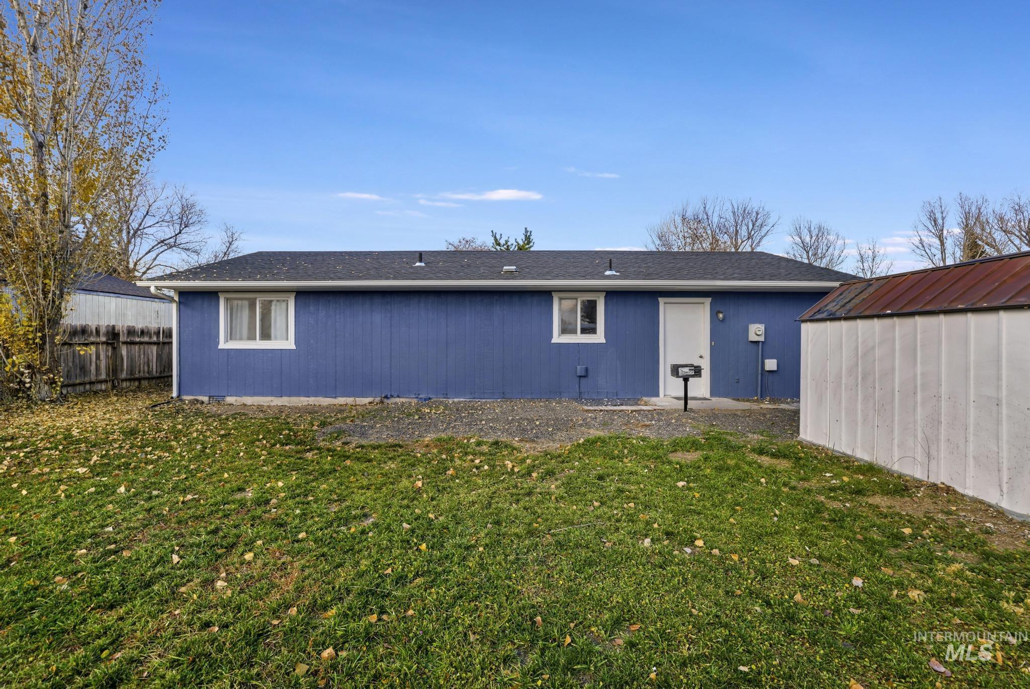 Rear view of house featuring an outdoor structure and a patio area