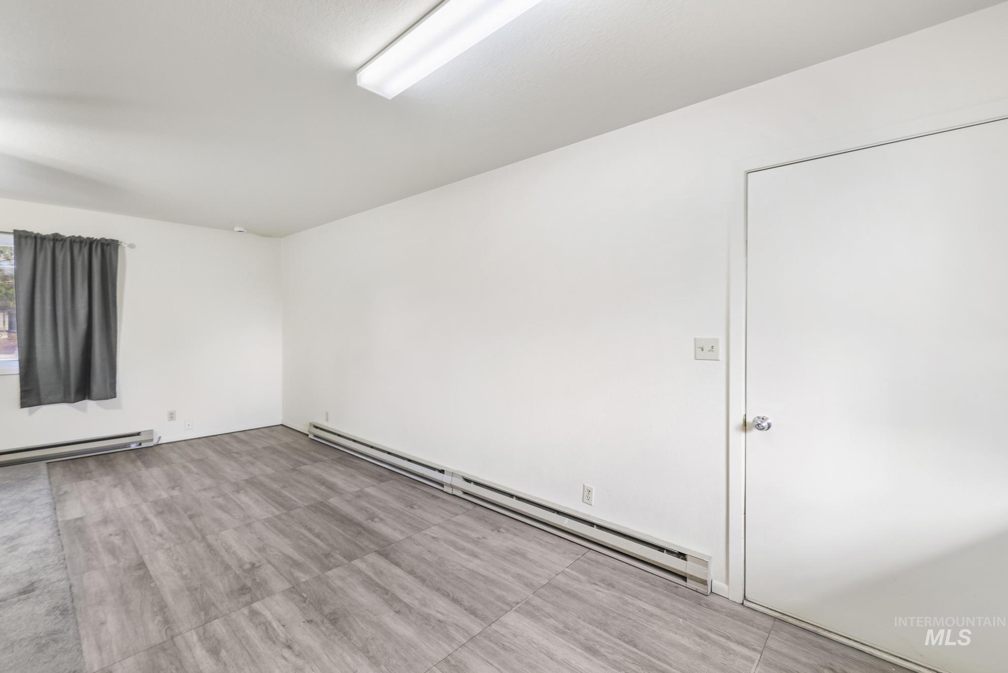 Empty room featuring baseboard heating