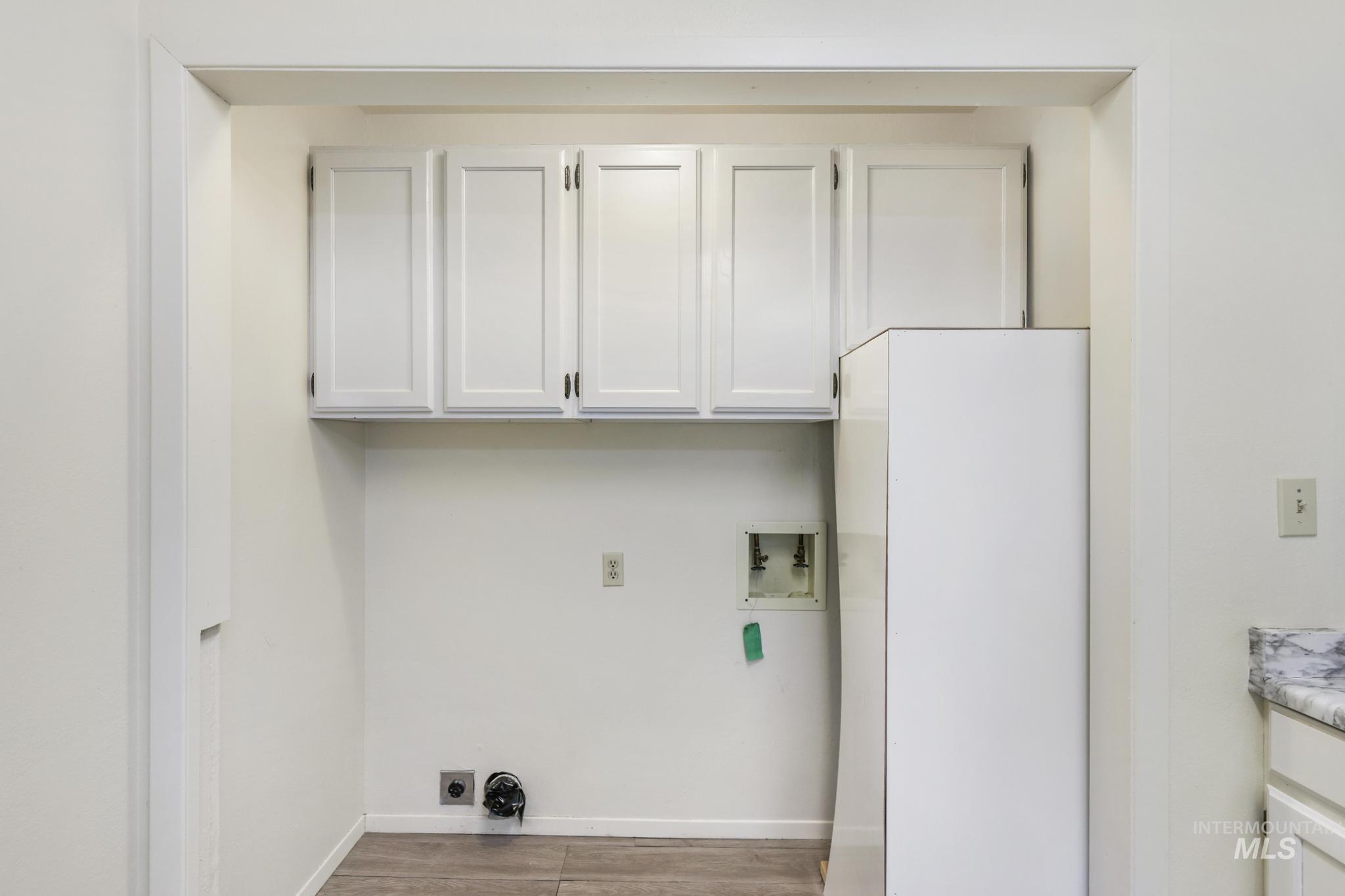 Laundry room featuring cabinet space, washer hookup, and light wood-style floors