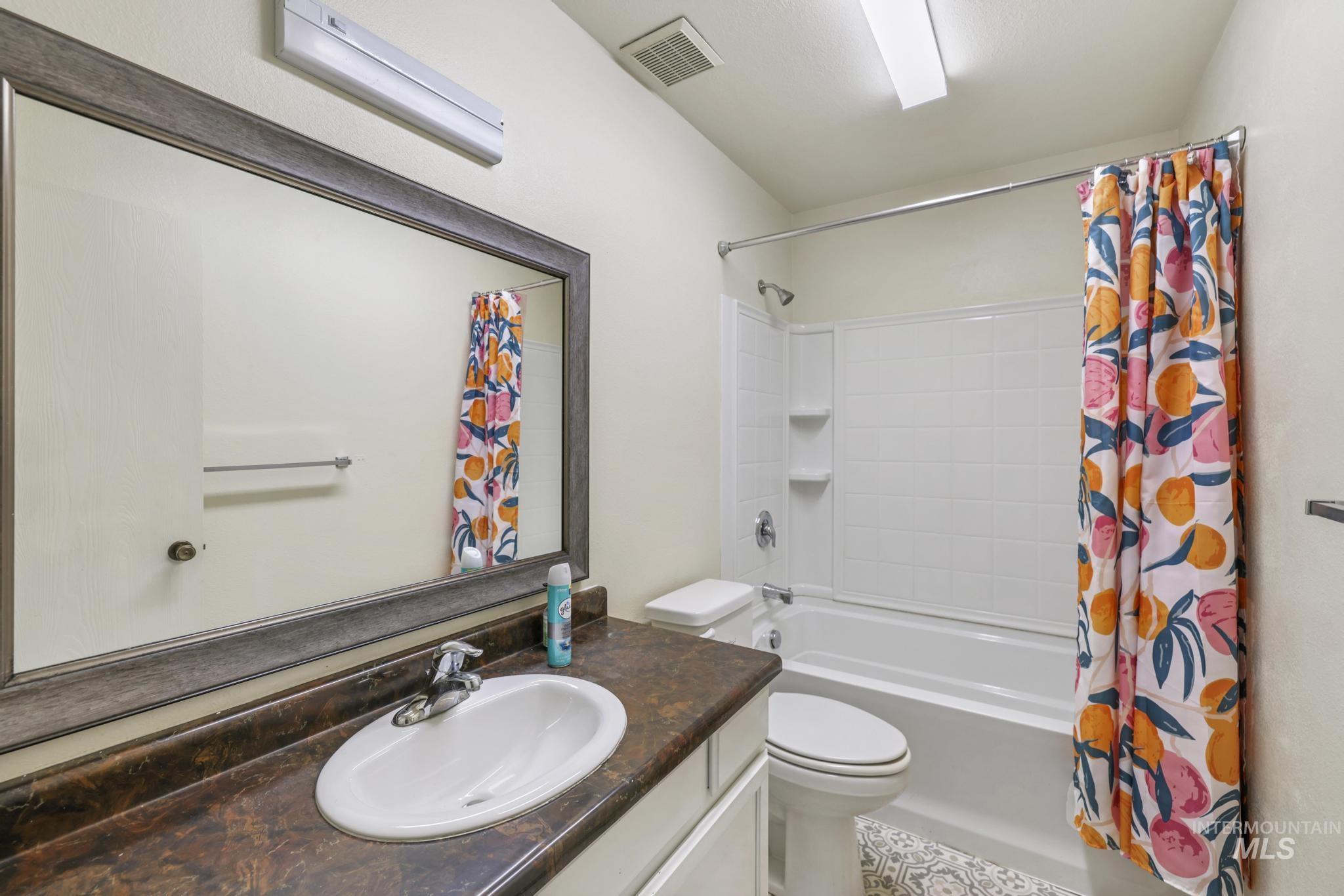 Bathroom with shower / tub combo and vanity