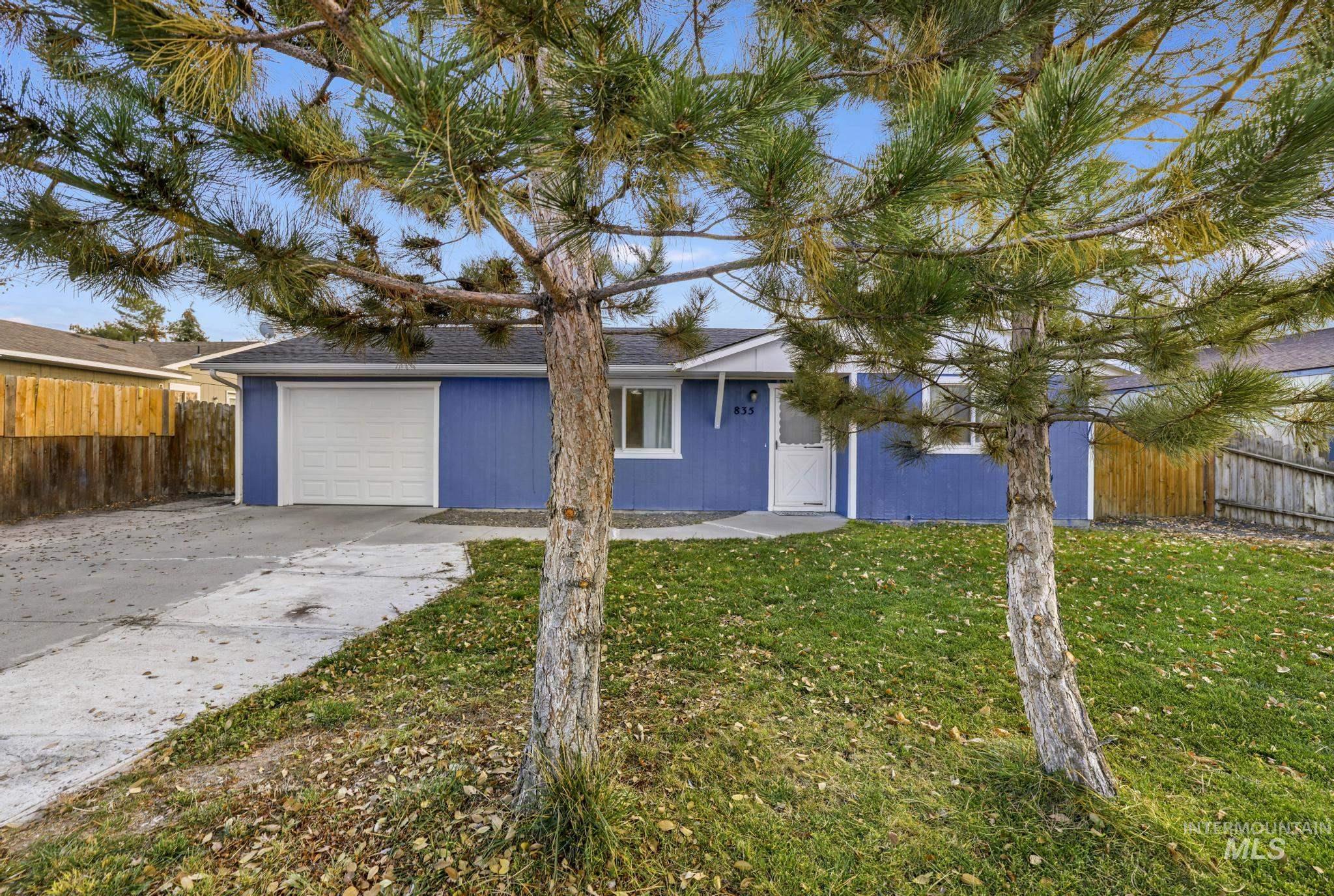 Single story home with concrete driveway, a shingled roof, and a garage