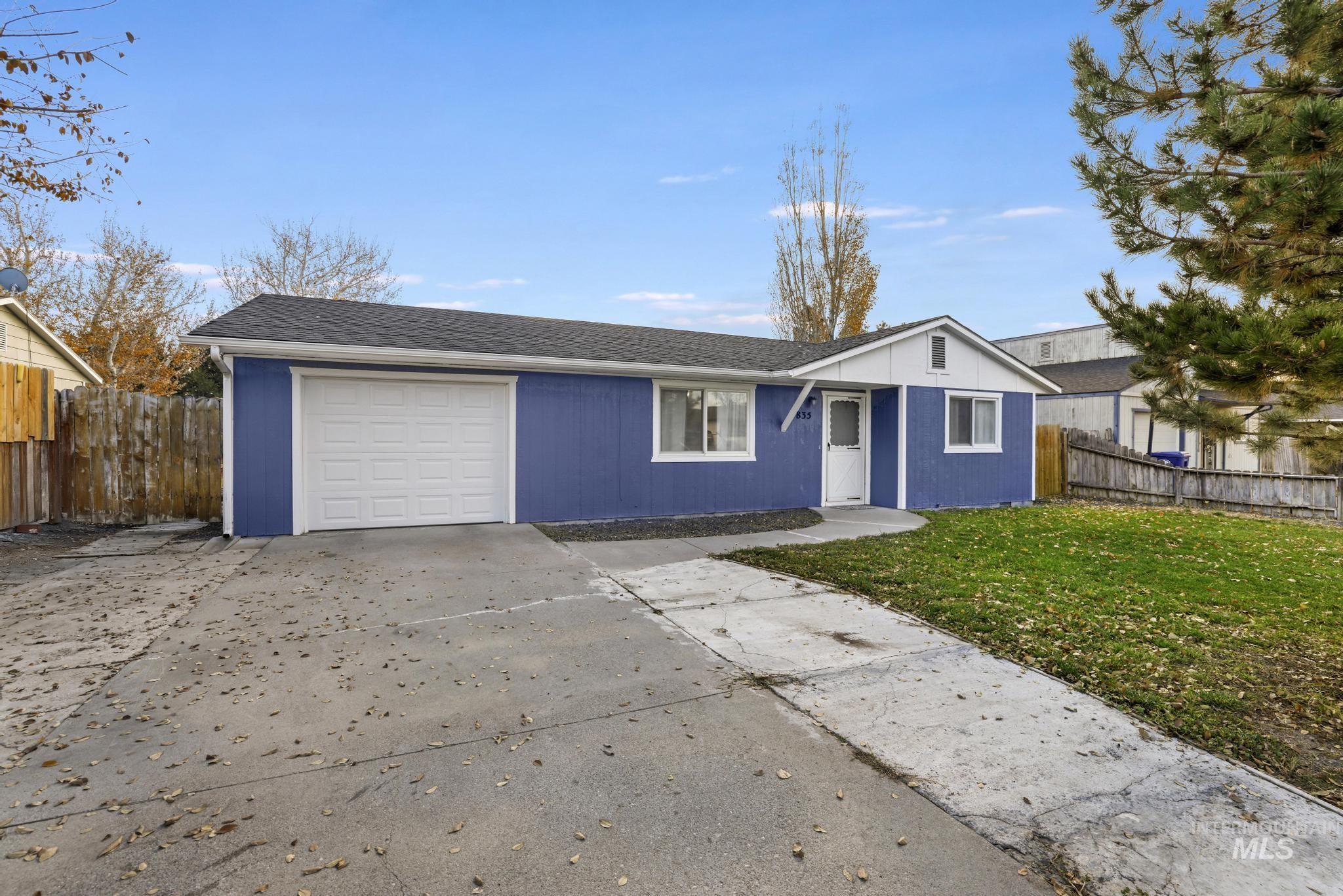 Ranch-style home featuring driveway, a shingled roof, and an attached garage