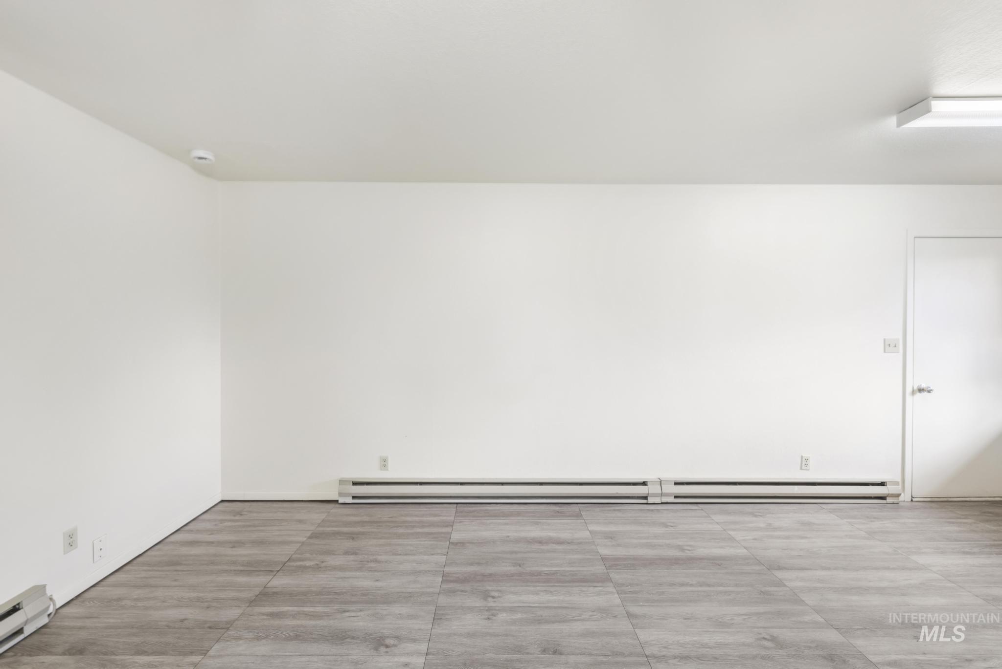 Unfurnished room featuring baseboard heating