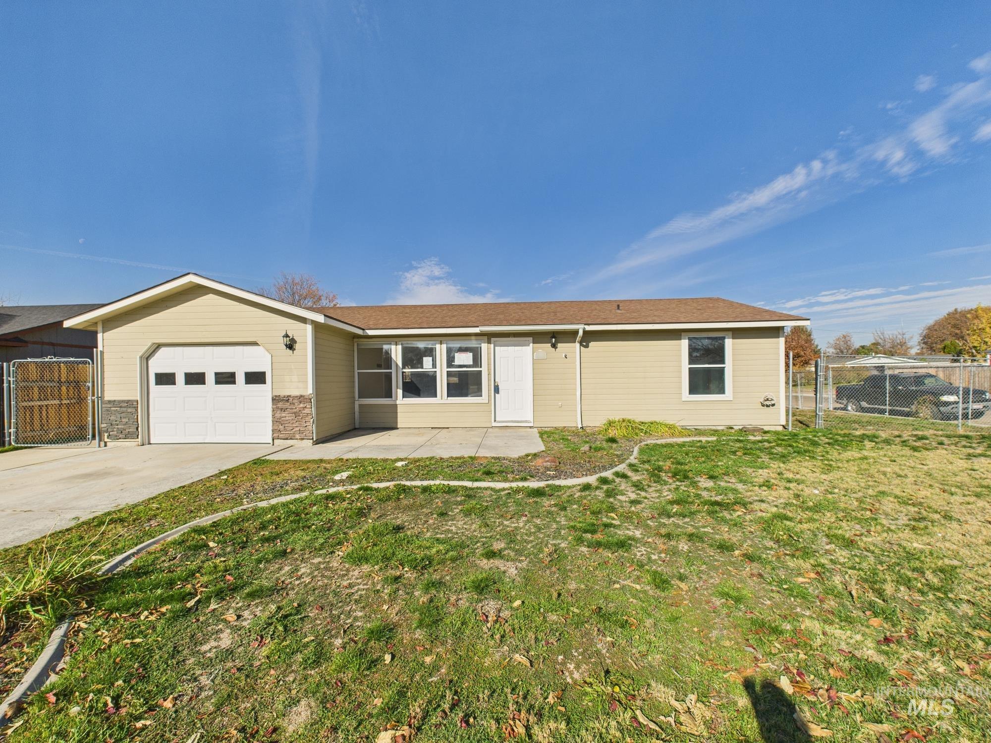 Ranch-style house featuring a garage, concrete driveway, a patio, and a gate