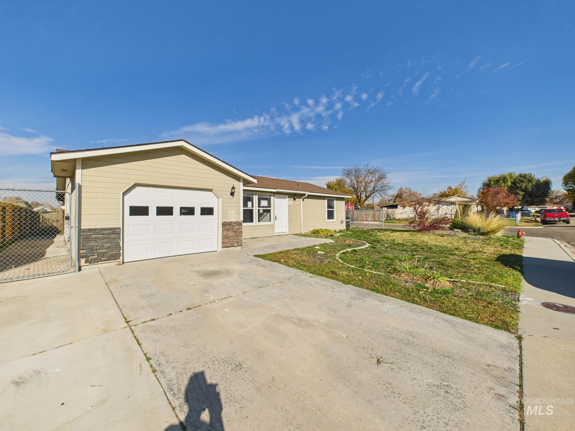 Ranch-style house with driveway, a garage, and stone siding