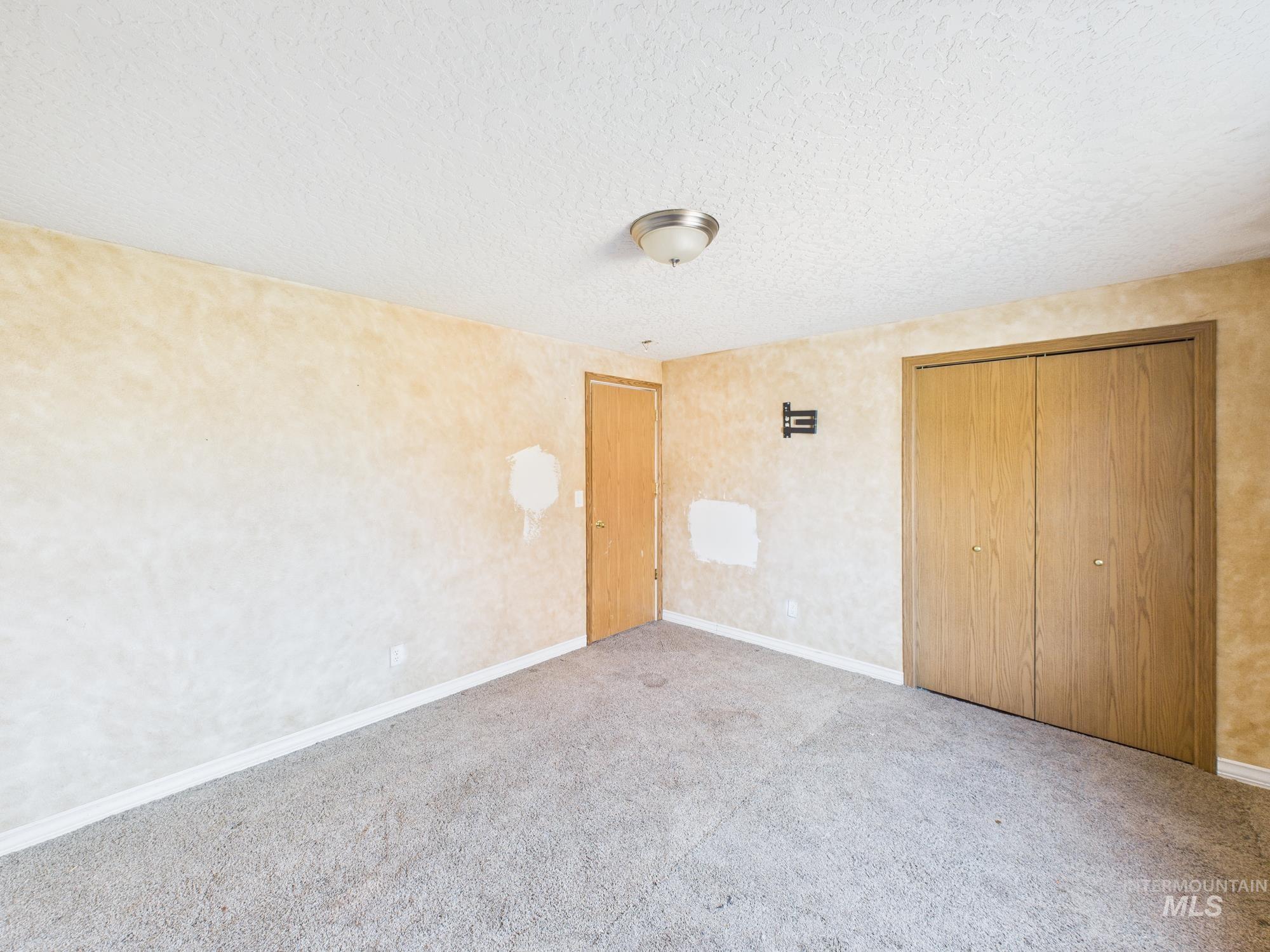 Unfurnished bedroom with a closet, carpet floors, and a textured ceiling