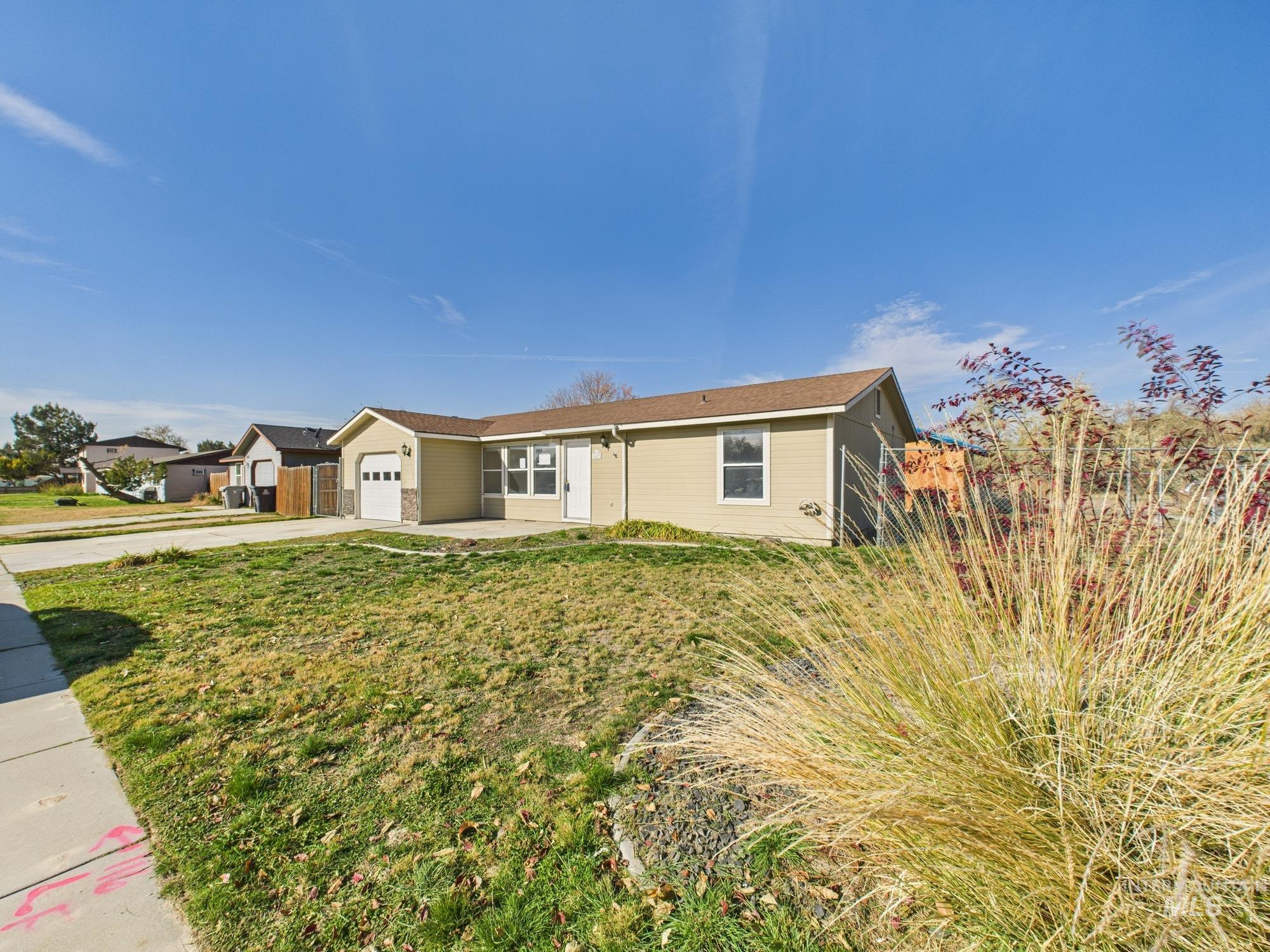 Ranch-style home with driveway, a garage, and a front yard