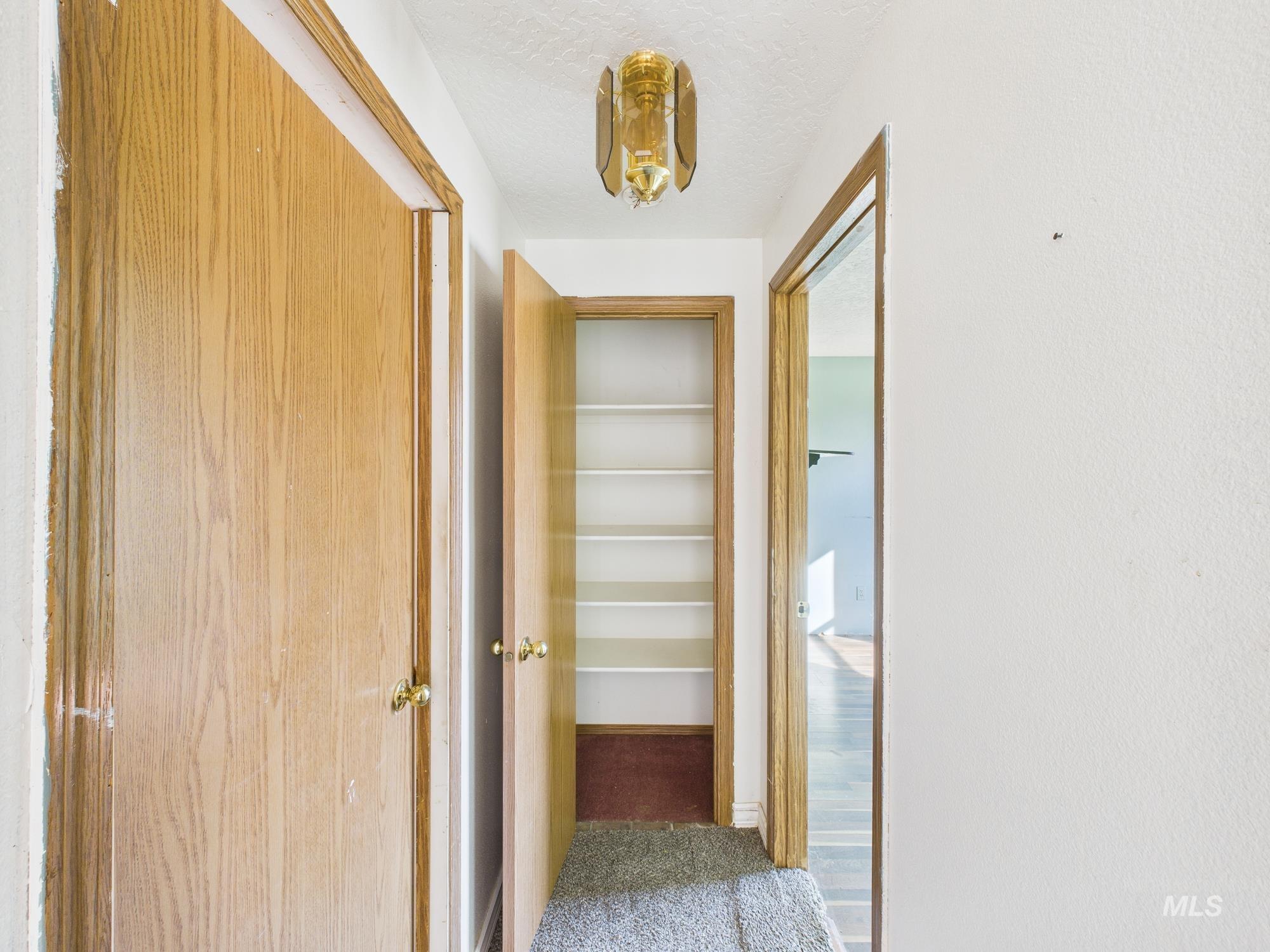 Hallway featuring carpet floors and a textured ceiling