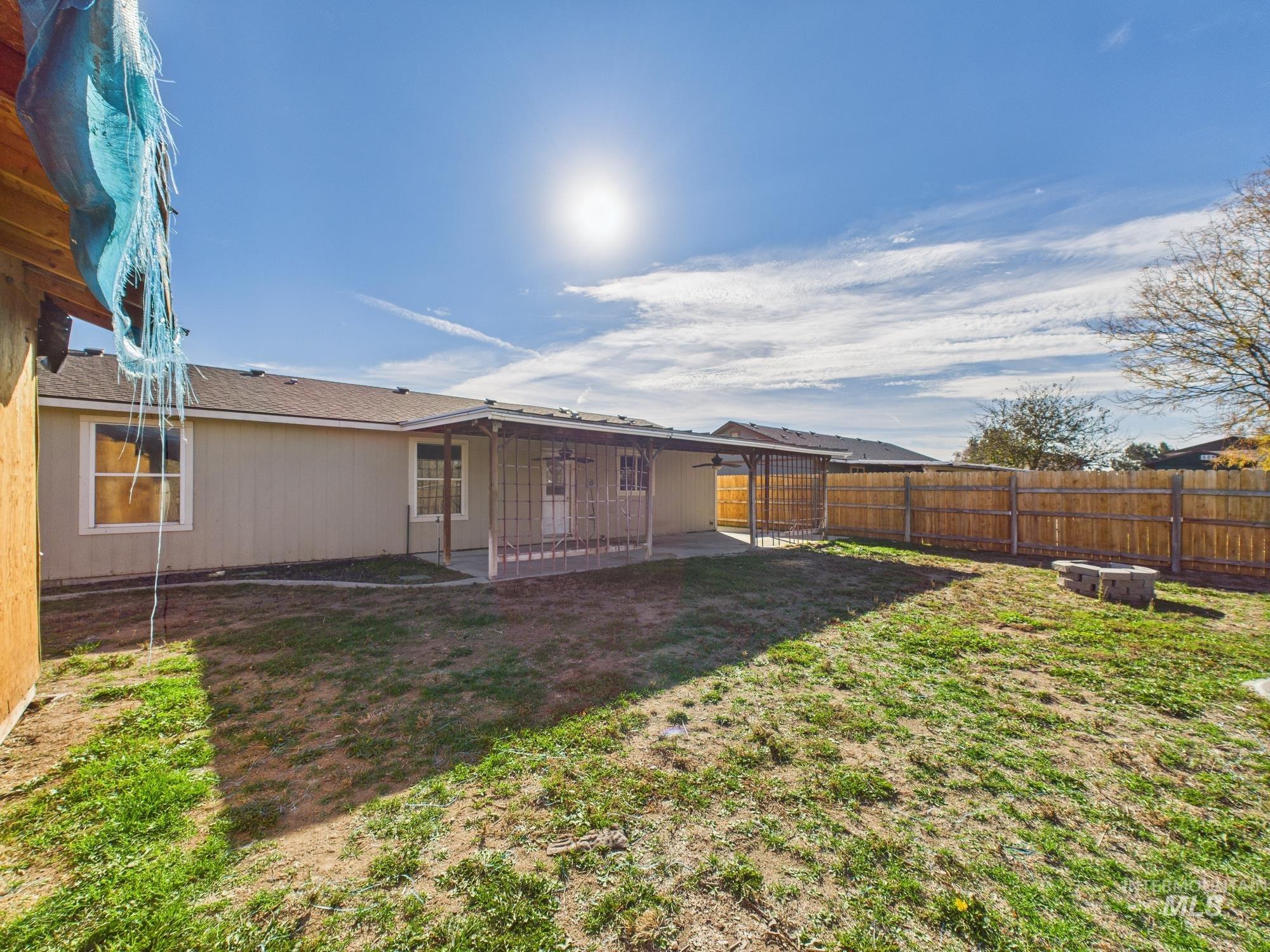 Rear view of property featuring a patio, a fenced backyard, and roof with shingles