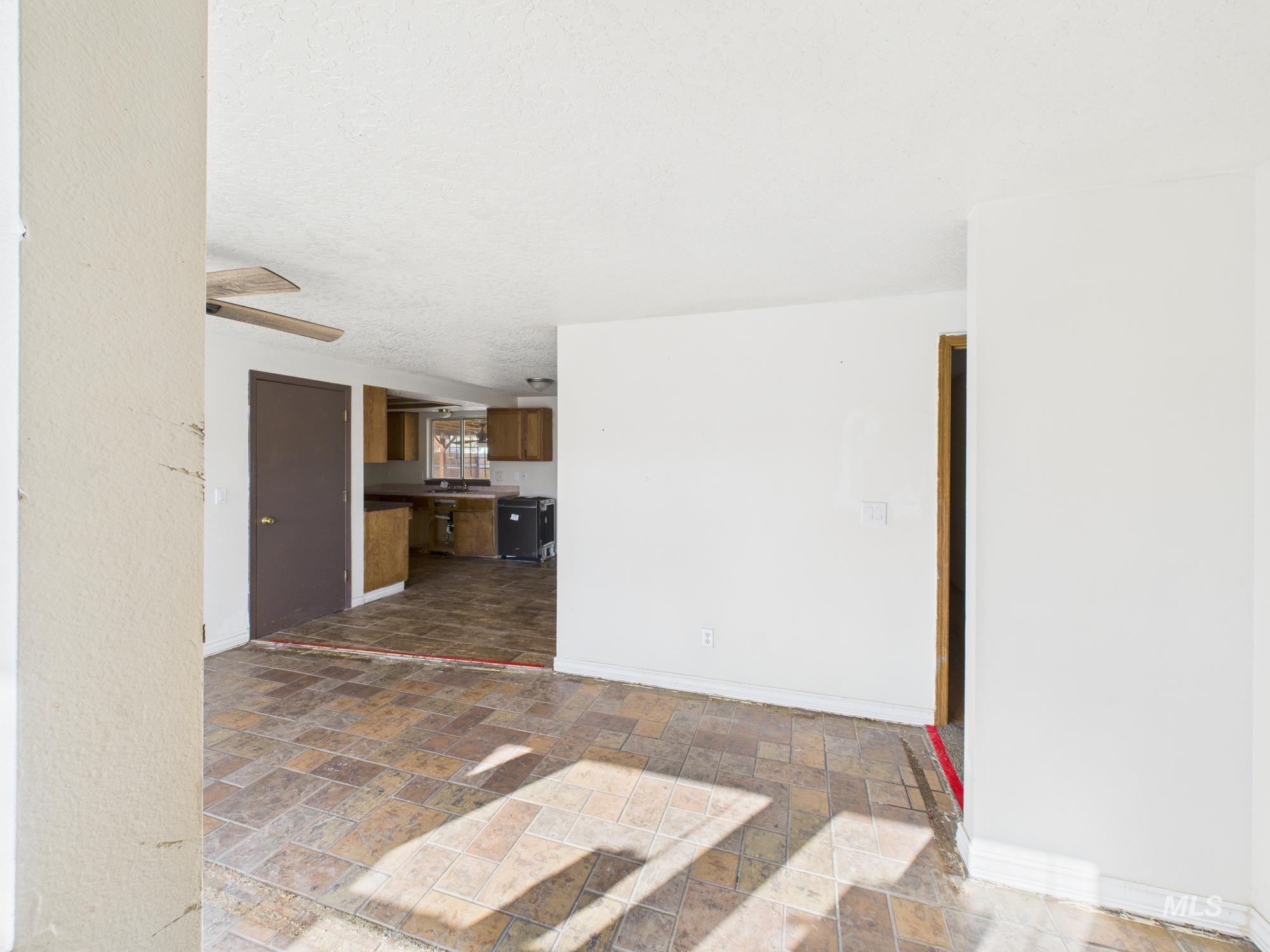 Unfurnished living room featuring dark stone finish floors and a textured ceiling