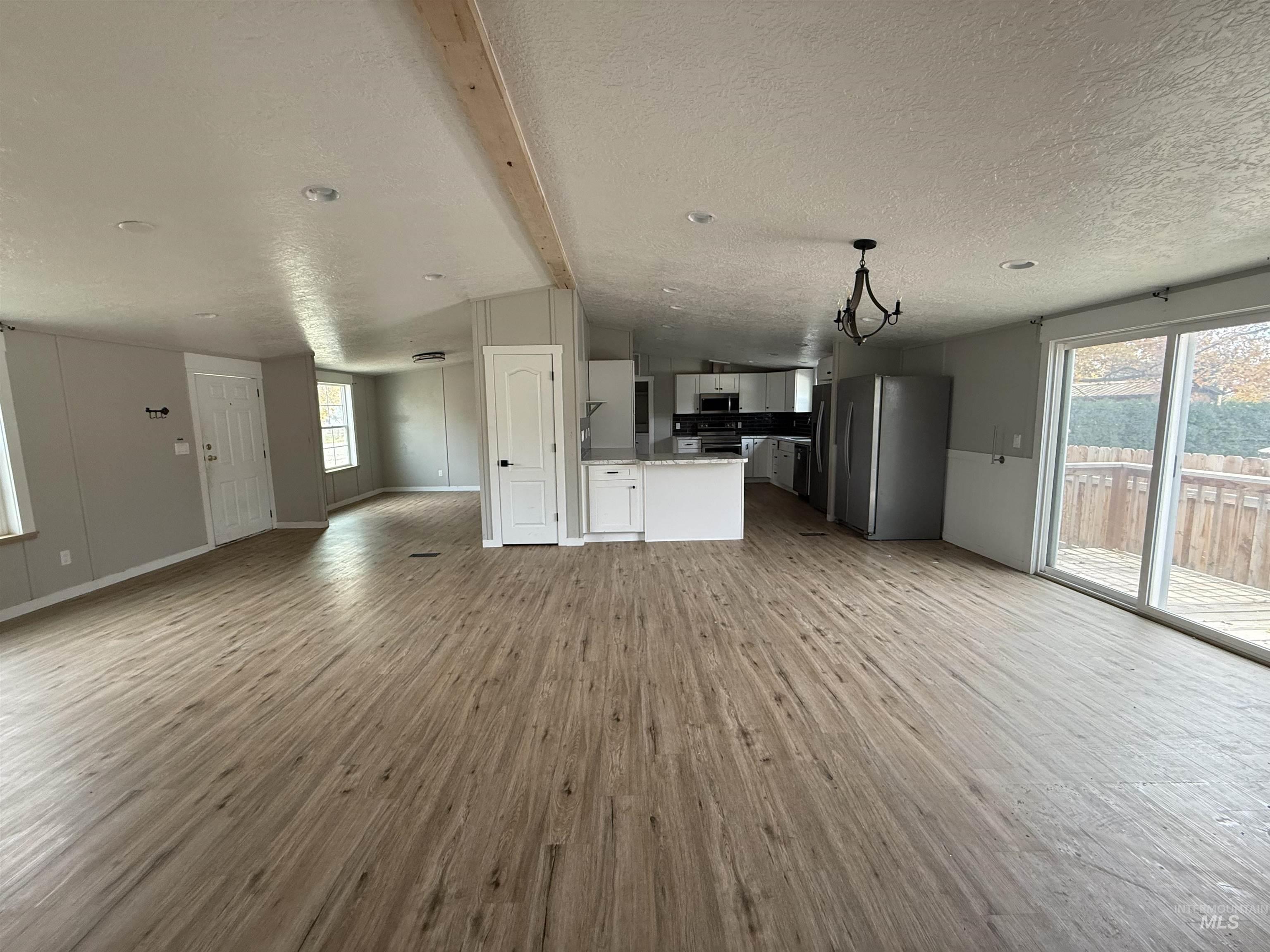 Unfurnished living room featuring light wood-style floors and a textured ceiling