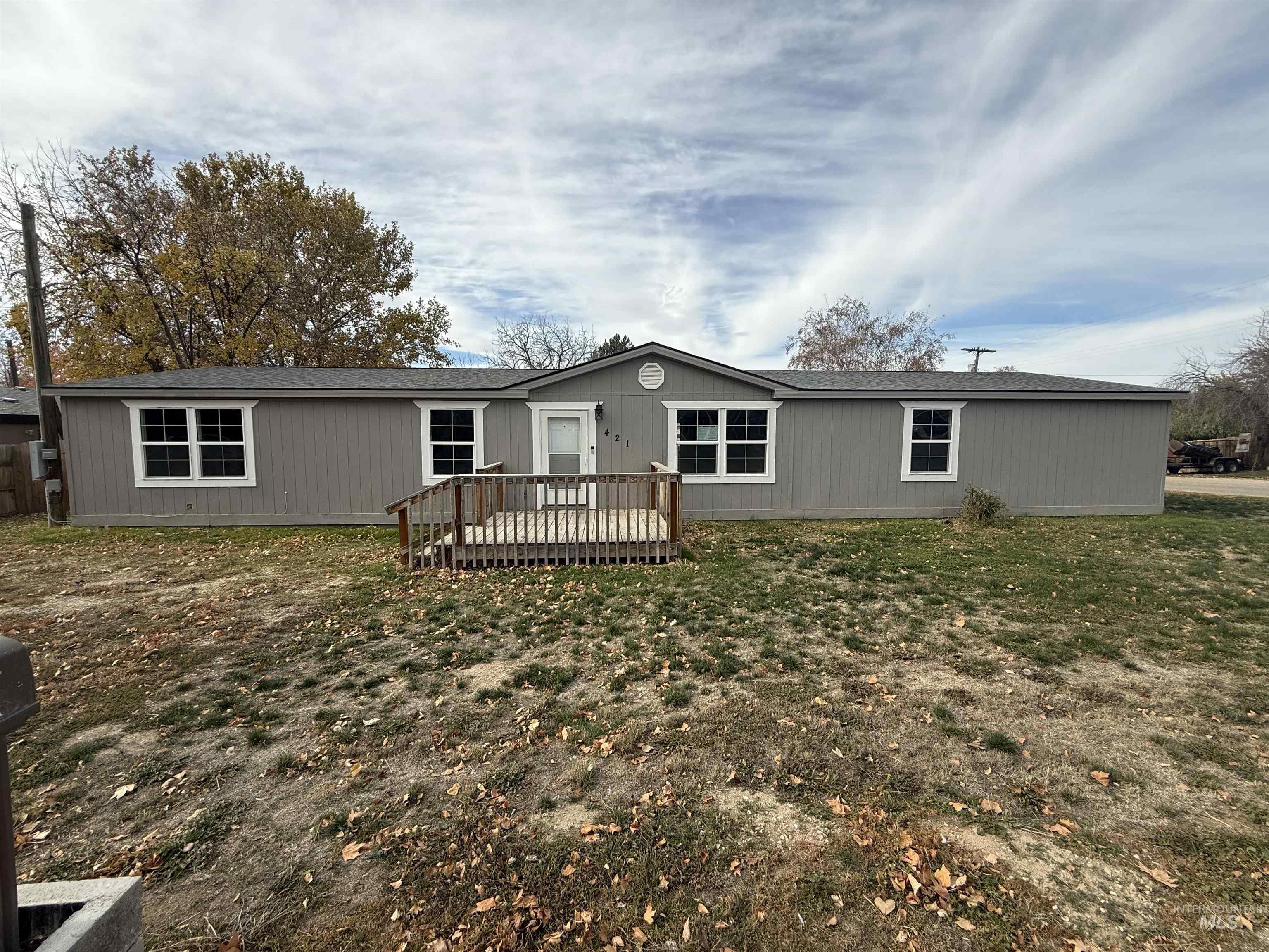 Rear view of house featuring a deck and a yard