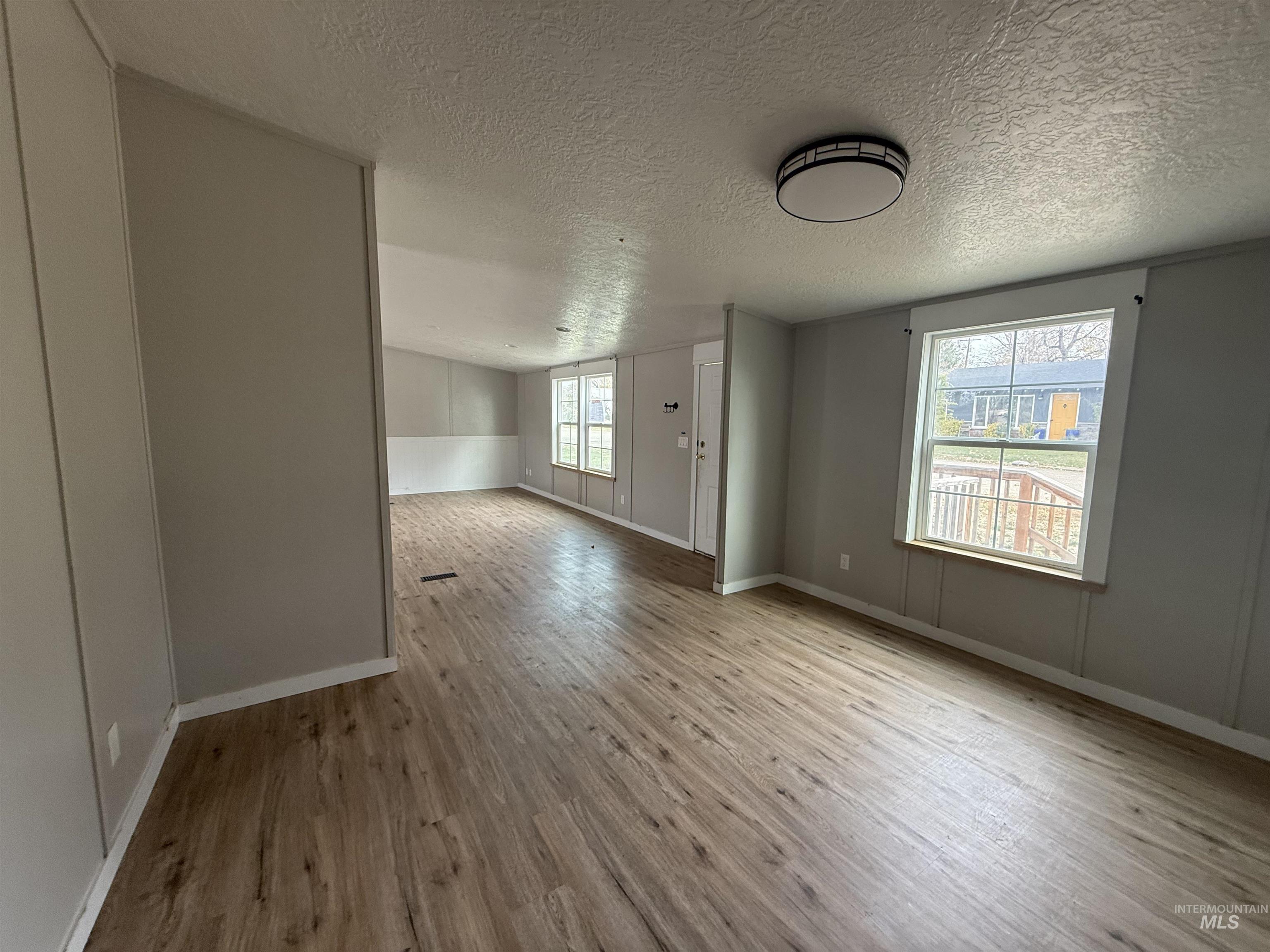 Unfurnished room featuring a textured ceiling and light wood finished floors