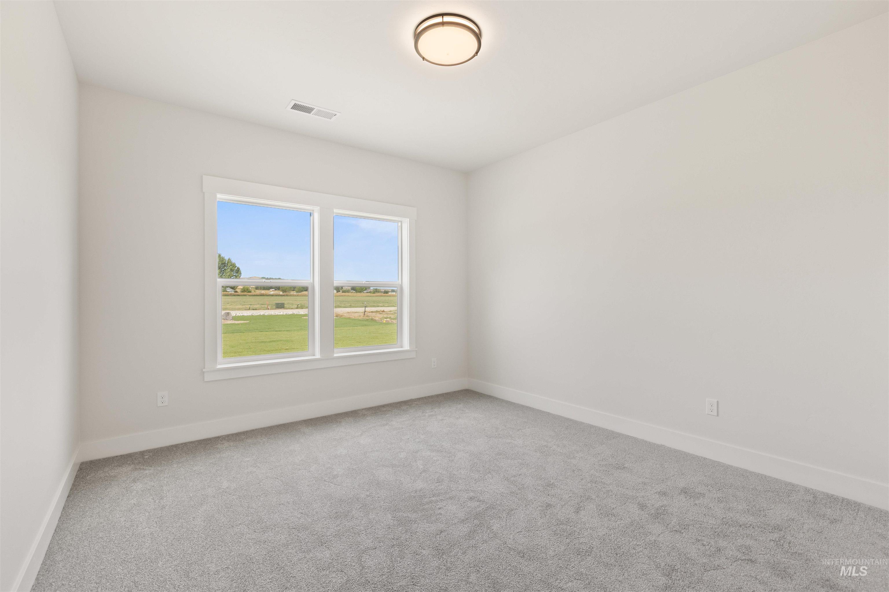 Carpeted spare room with baseboards