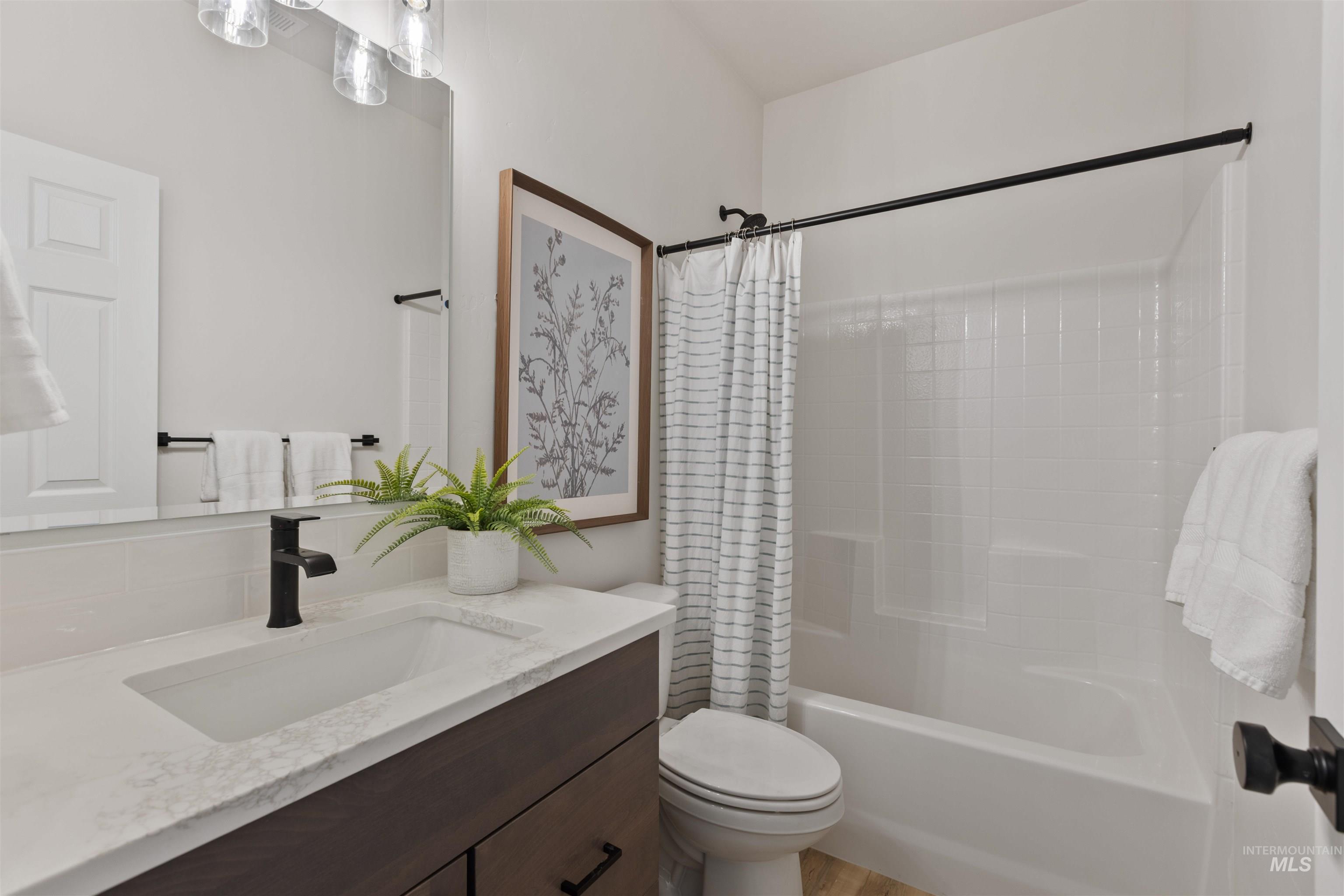 Bathroom featuring shower / bath combo with shower curtain and vanity
