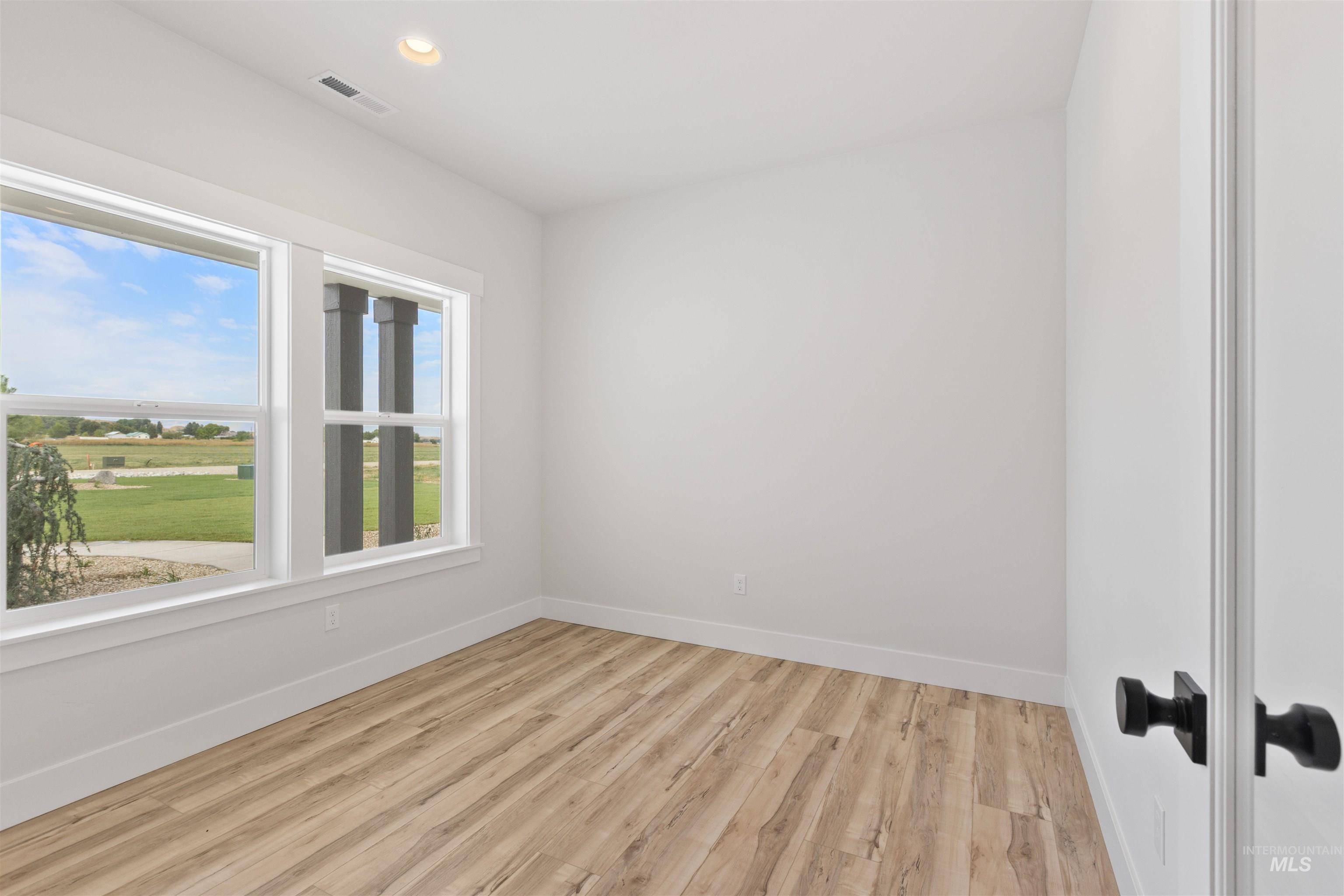 Empty room featuring light wood-style floors and recessed lighting