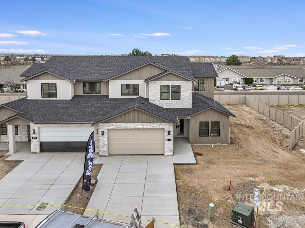 View of front facade with roof with shingles, concrete driveway, a residential view, stone siding, and a garage