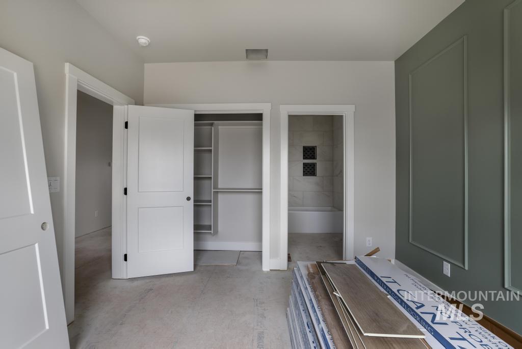 Unfurnished bedroom with a closet, concrete floors, and connected bathroom