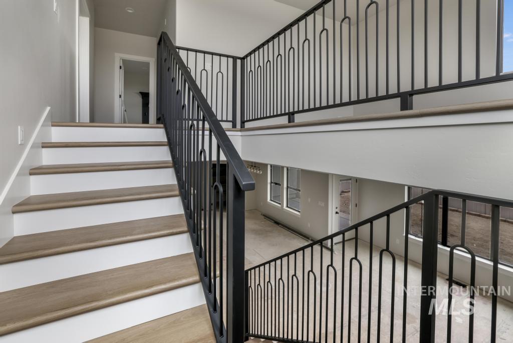 Stairway featuring wood finished floors and a high ceiling