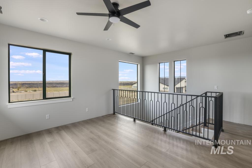 Unfurnished room with light wood-style floors and a ceiling fan