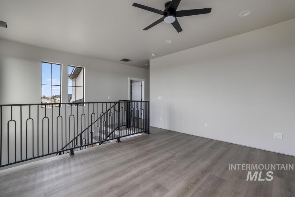 Empty room with light wood-type flooring and a ceiling fan