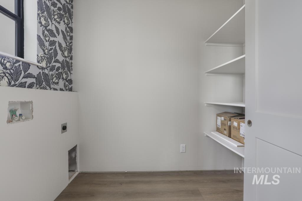 Laundry room featuring light wood-type flooring, hookup for a washing machine, and electric dryer hookup