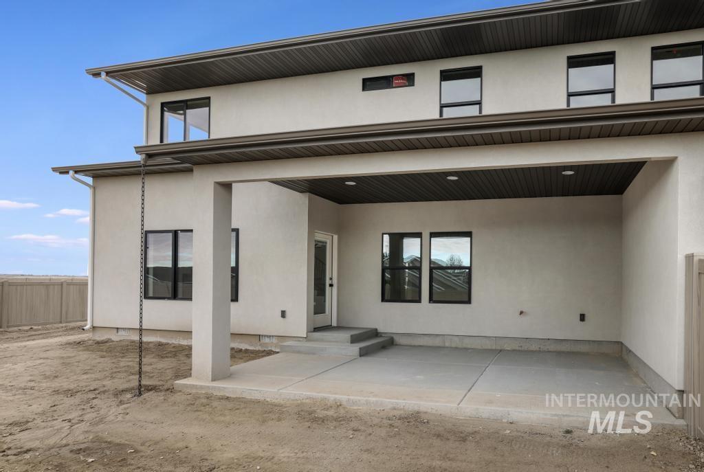 Rear view of house featuring stucco siding and a patio
