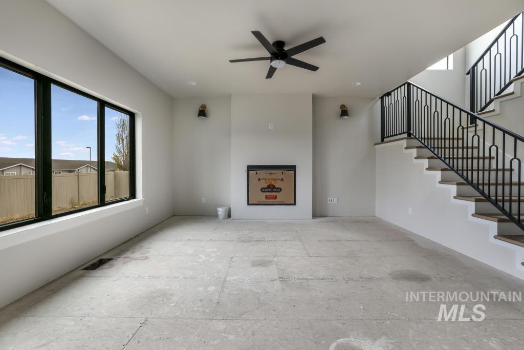 Unfurnished living room featuring ceiling fan