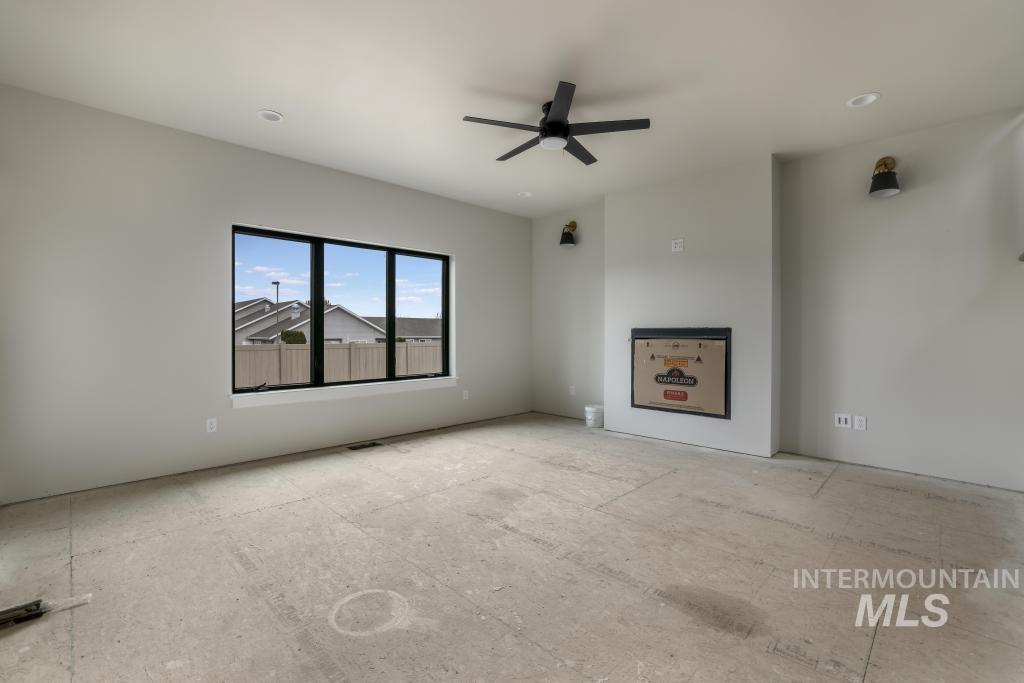 Unfurnished living room featuring ceiling fan