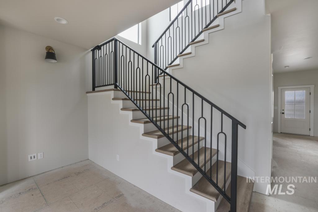 Stairs featuring healthy amount of natural light and concrete flooring