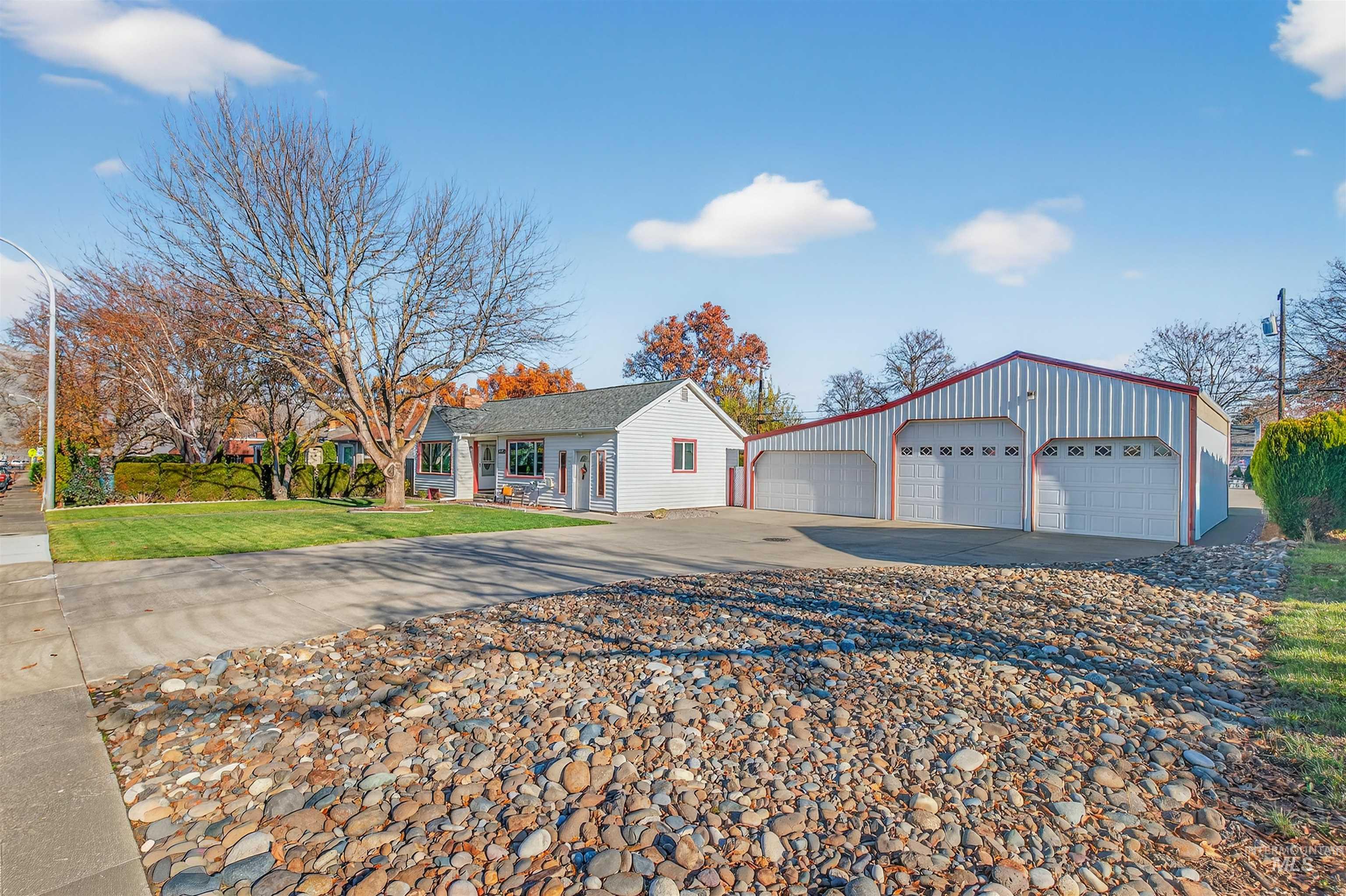 View of front facade featuring an outbuilding, a front lawn, and a garage