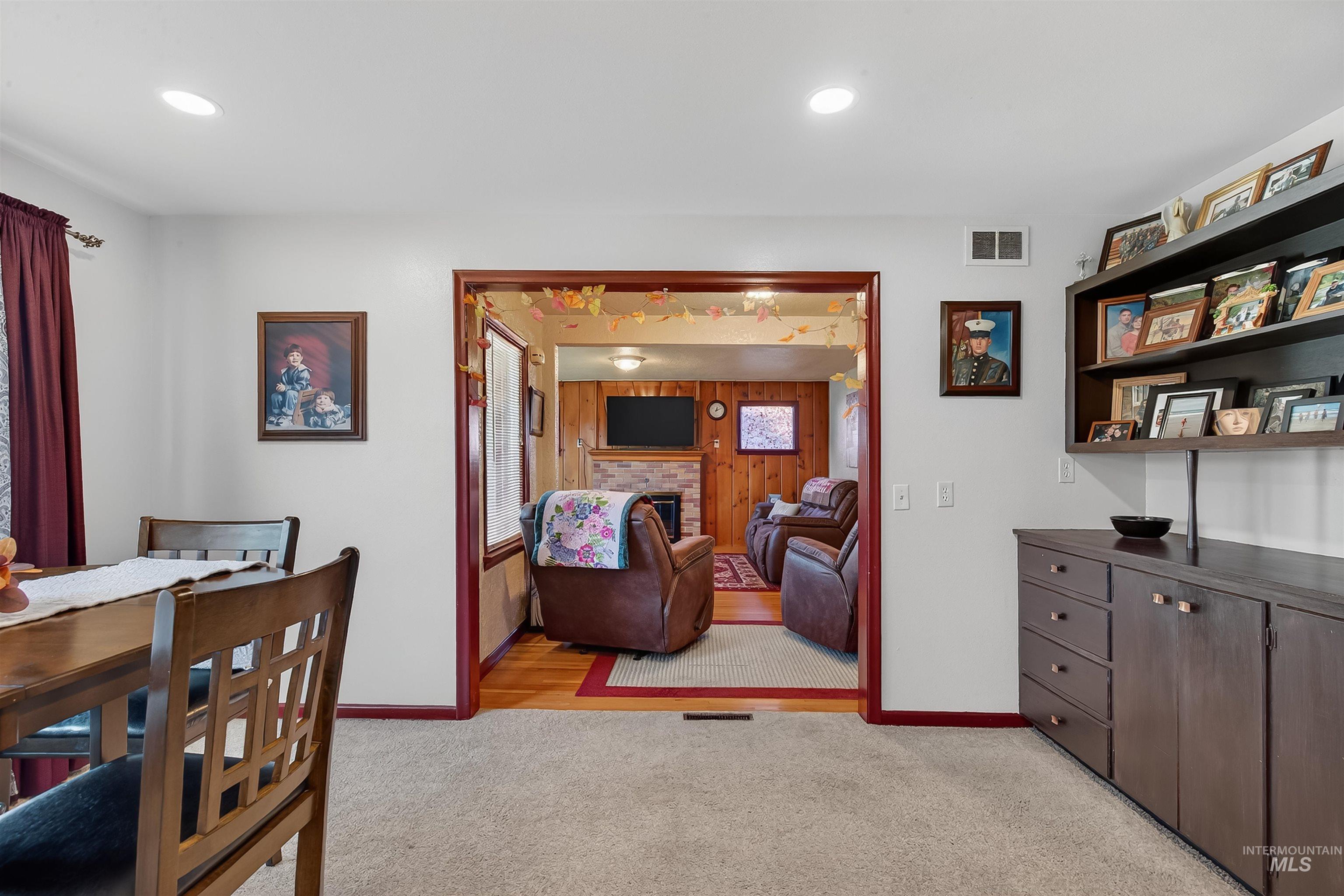 Dining area with light colored carpet, a fireplace, and recessed lighting