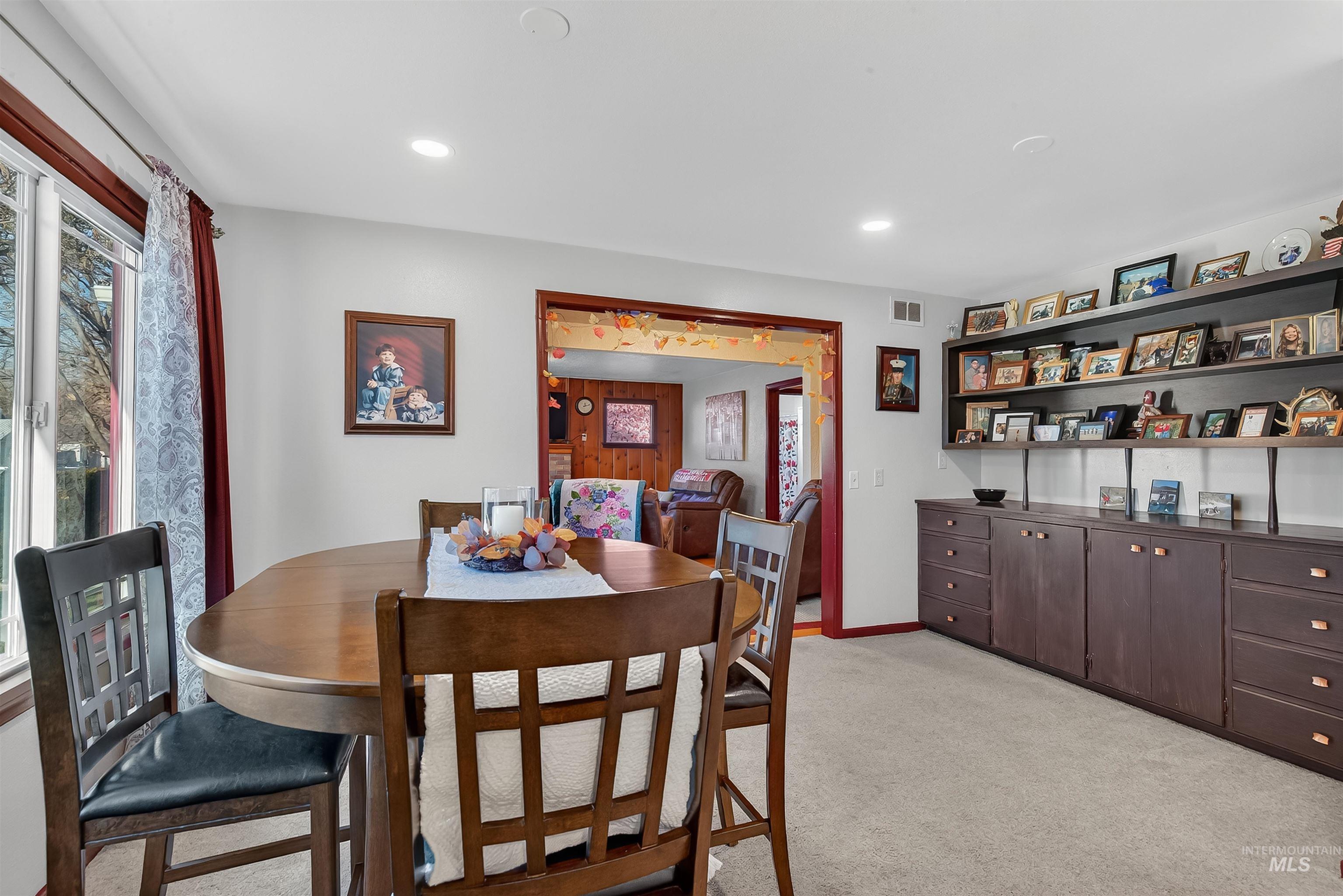 Dining area with light carpet and recessed lighting