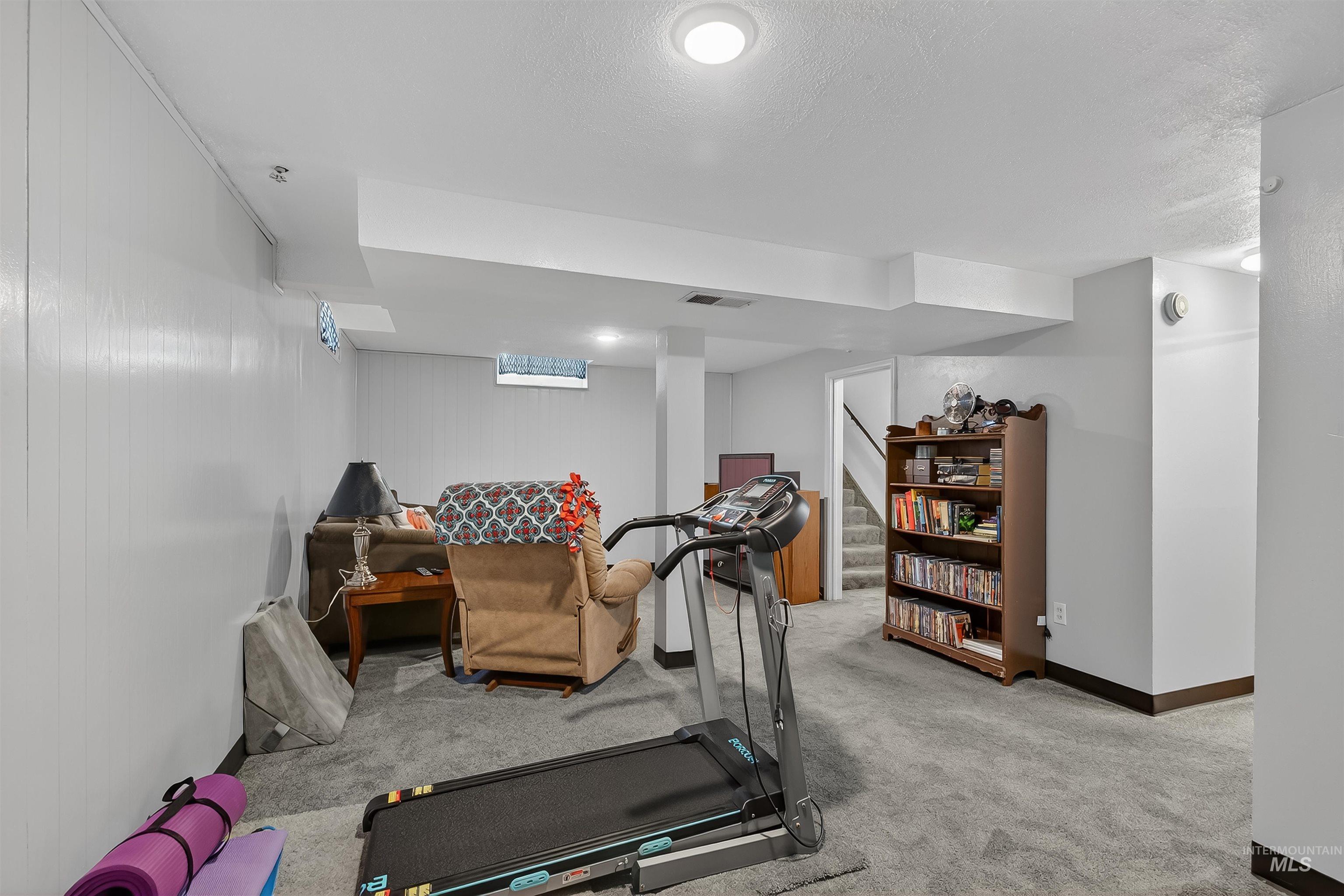 Workout room featuring carpet and a textured ceiling