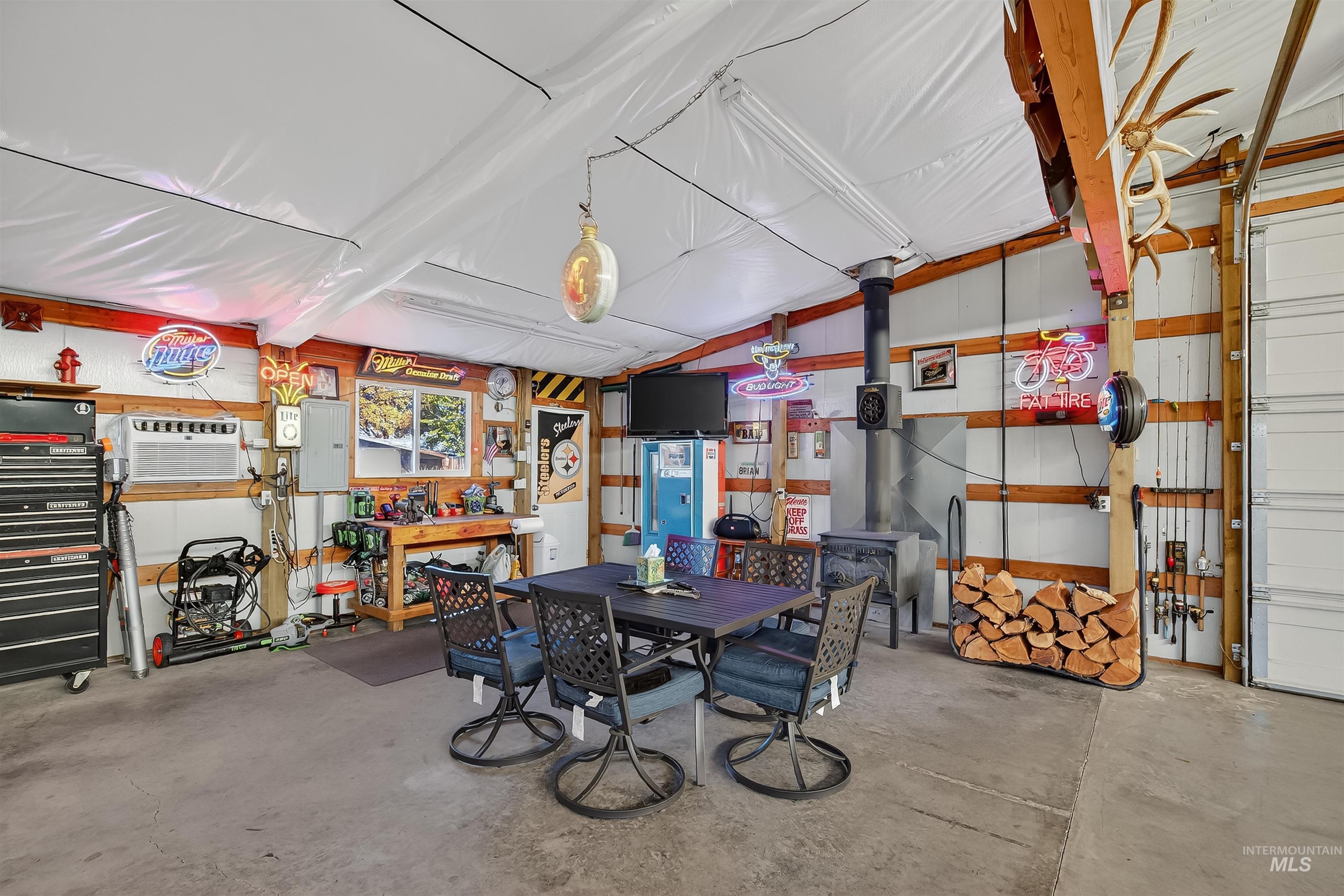 Garage featuring a workshop area, electric panel, and a wall unit AC