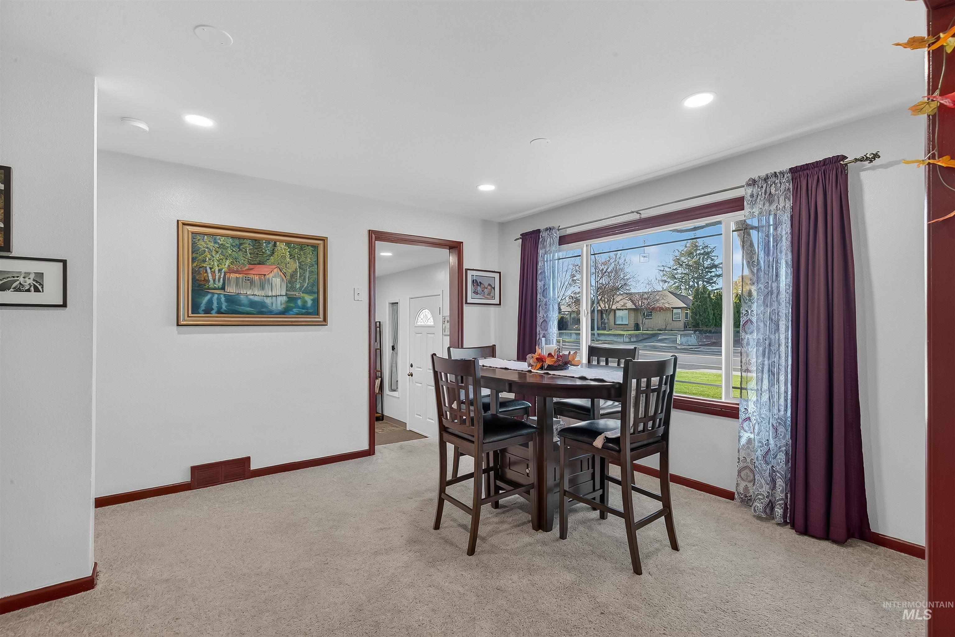 Dining space featuring light colored carpet and recessed lighting