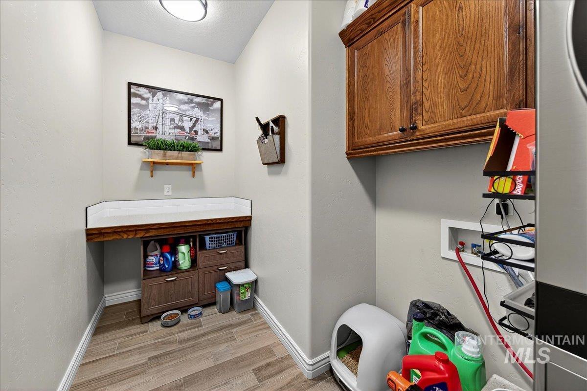 Laundry room with cabinet space, light wood-style flooring, and washer hookup