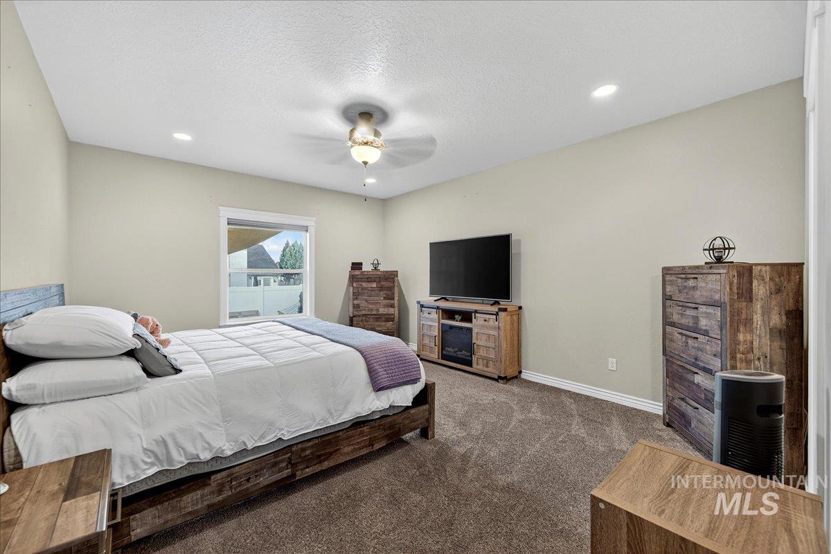 Bedroom featuring carpet, a textured ceiling, ceiling fan, and recessed lighting
