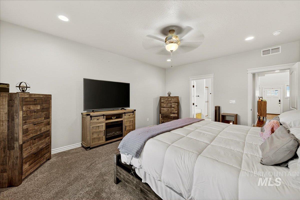 Carpeted bedroom featuring recessed lighting, a ceiling fan, and a textured ceiling