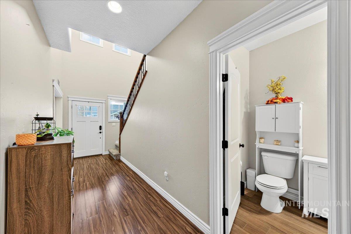 Entryway featuring dark wood-style floors and stairs