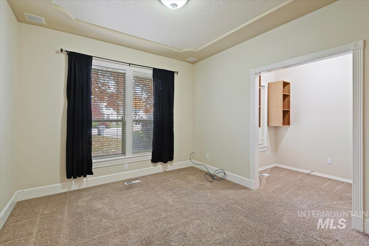 Unfurnished room with light carpet and a textured ceiling