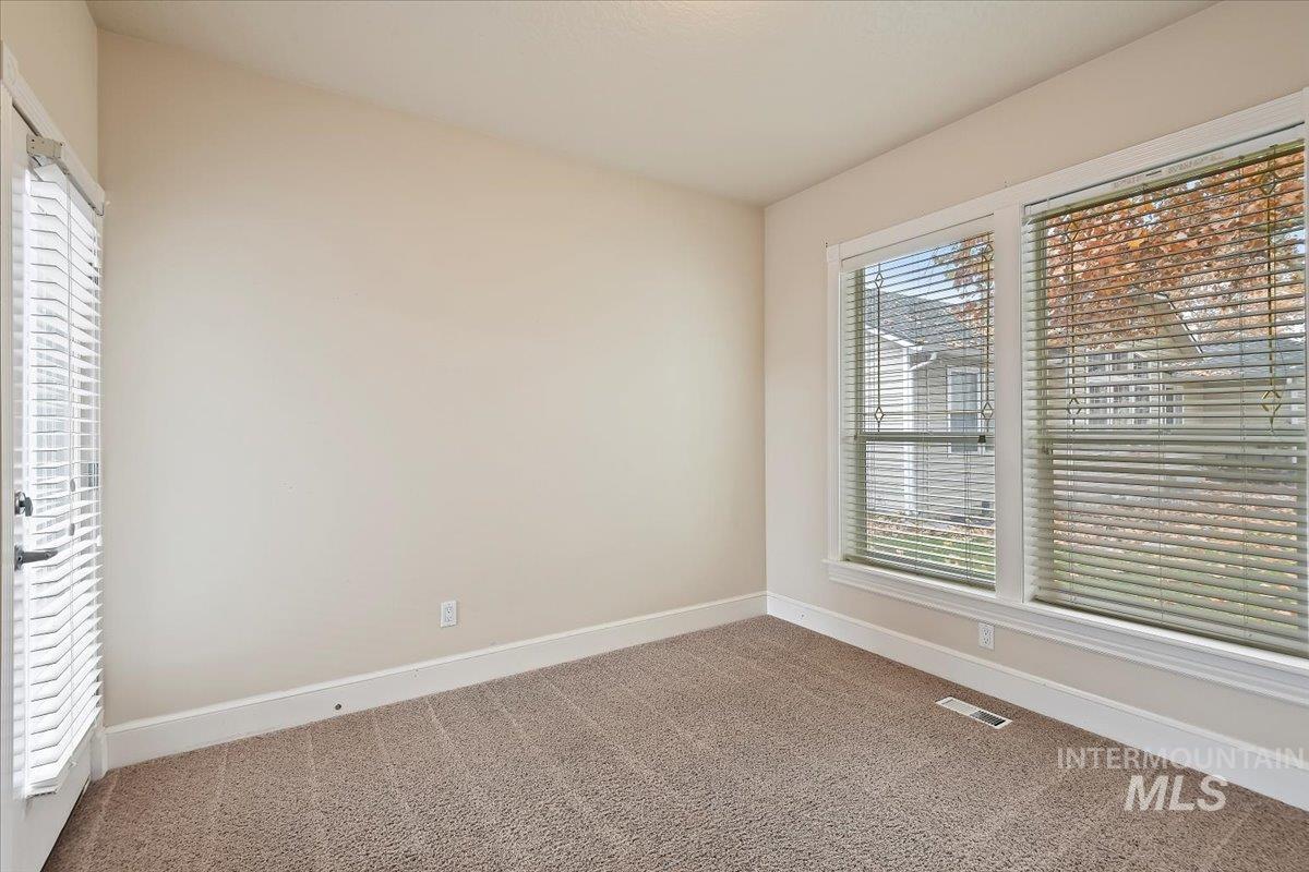 Spare room featuring baseboards and carpet flooring