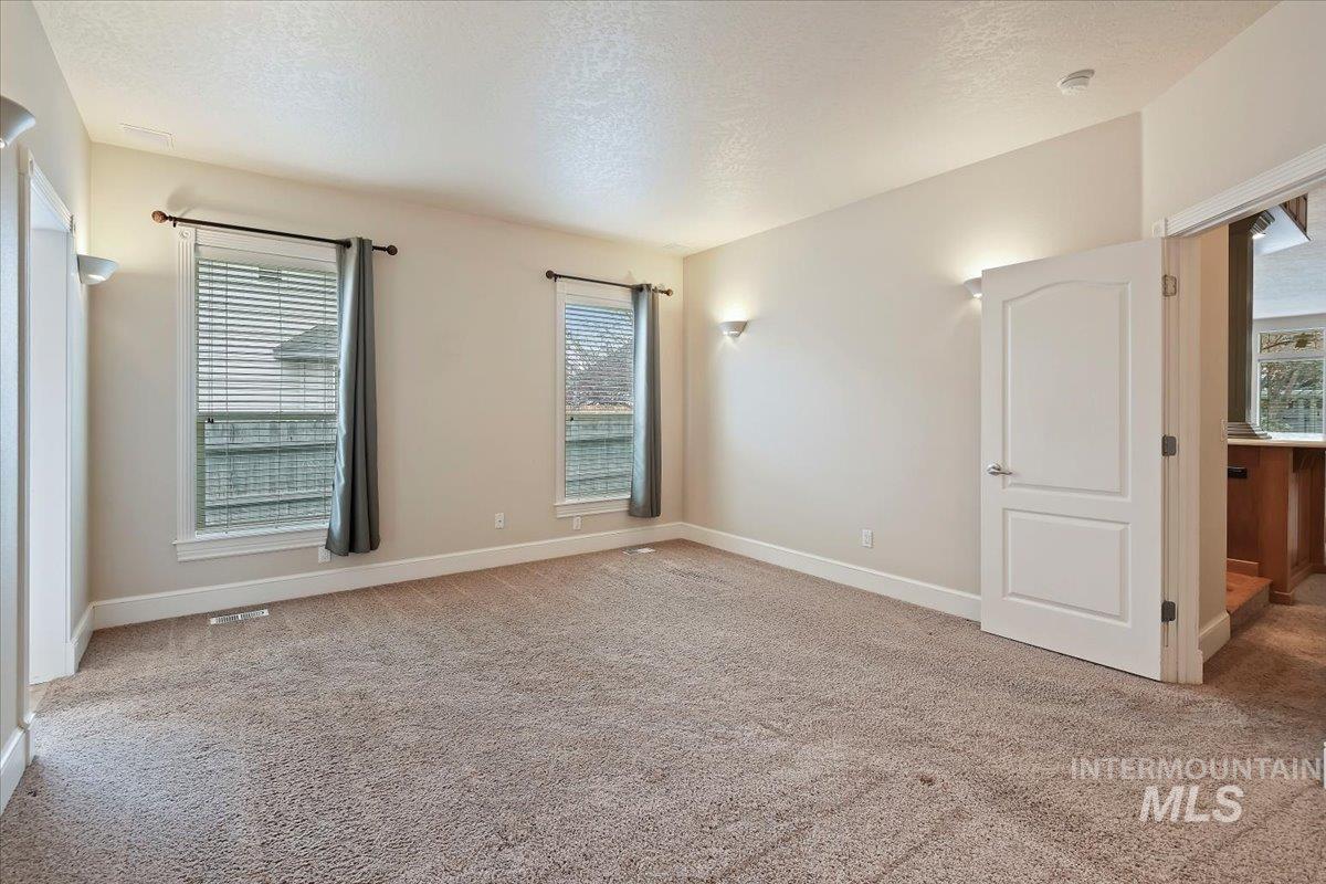 Spare room with a textured ceiling and light colored carpet