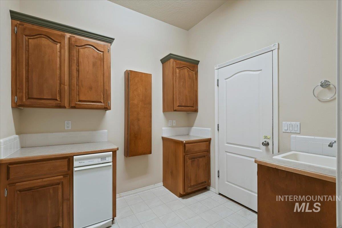 Kitchen with light countertops and brown cabinetry