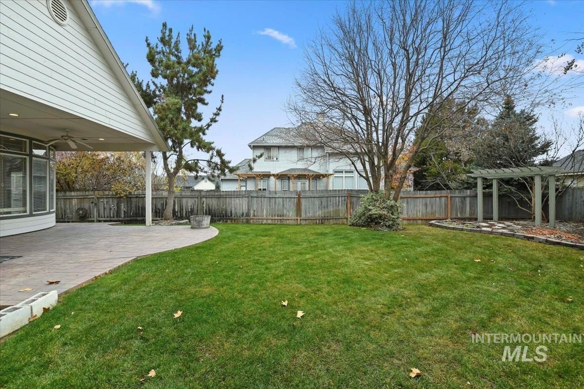 Fenced backyard featuring a patio area and ceiling fan