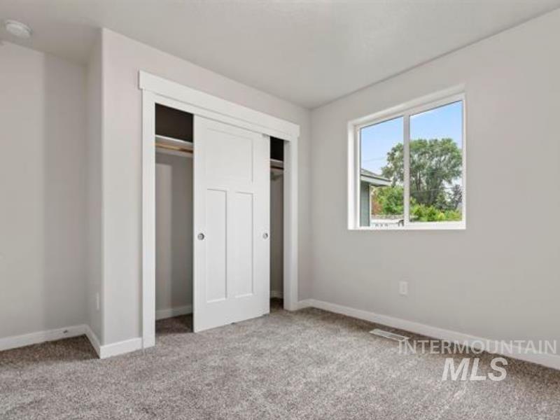 Unfurnished bedroom featuring light colored carpet and a closet