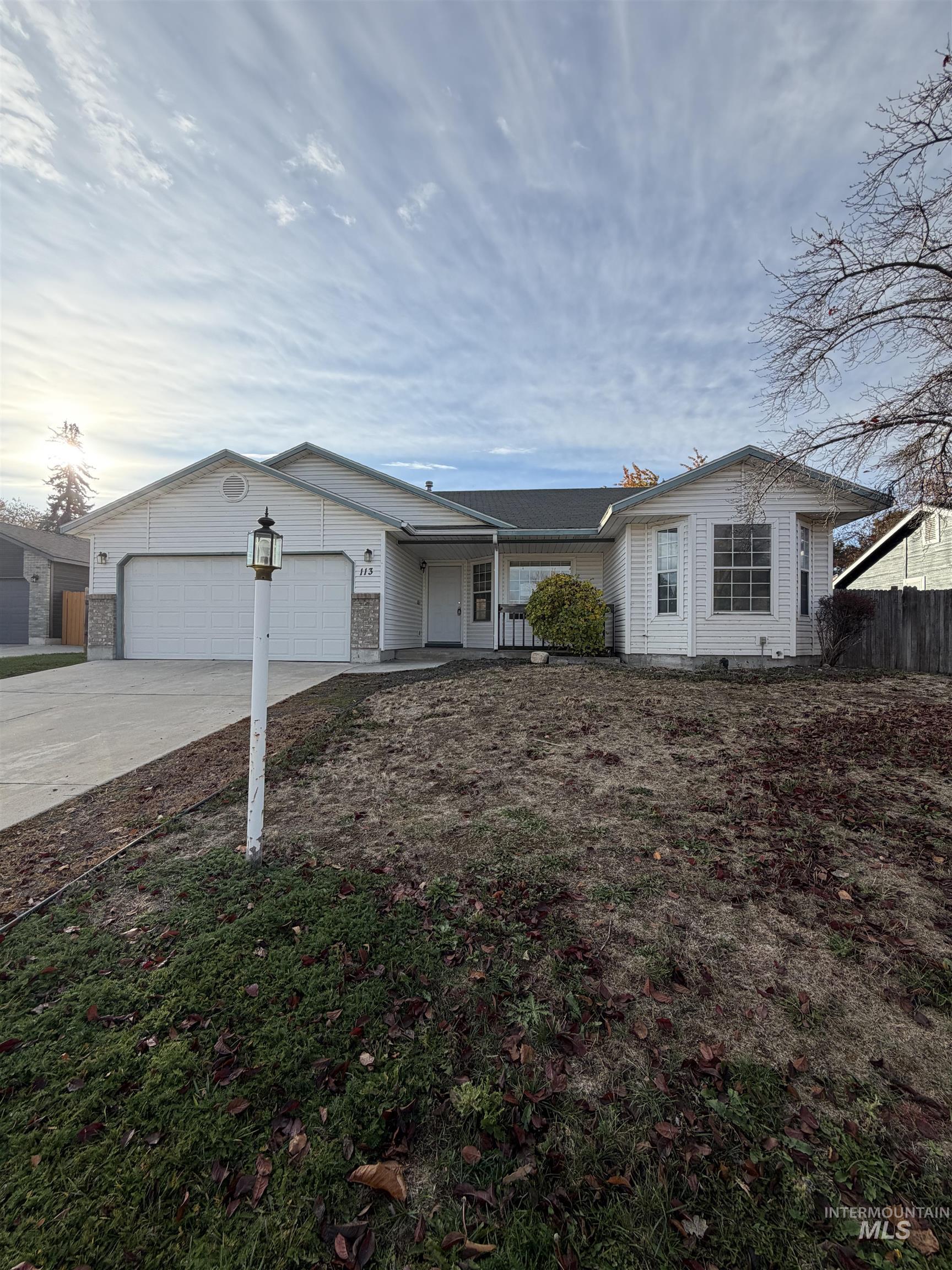 Single story home with driveway and a garage