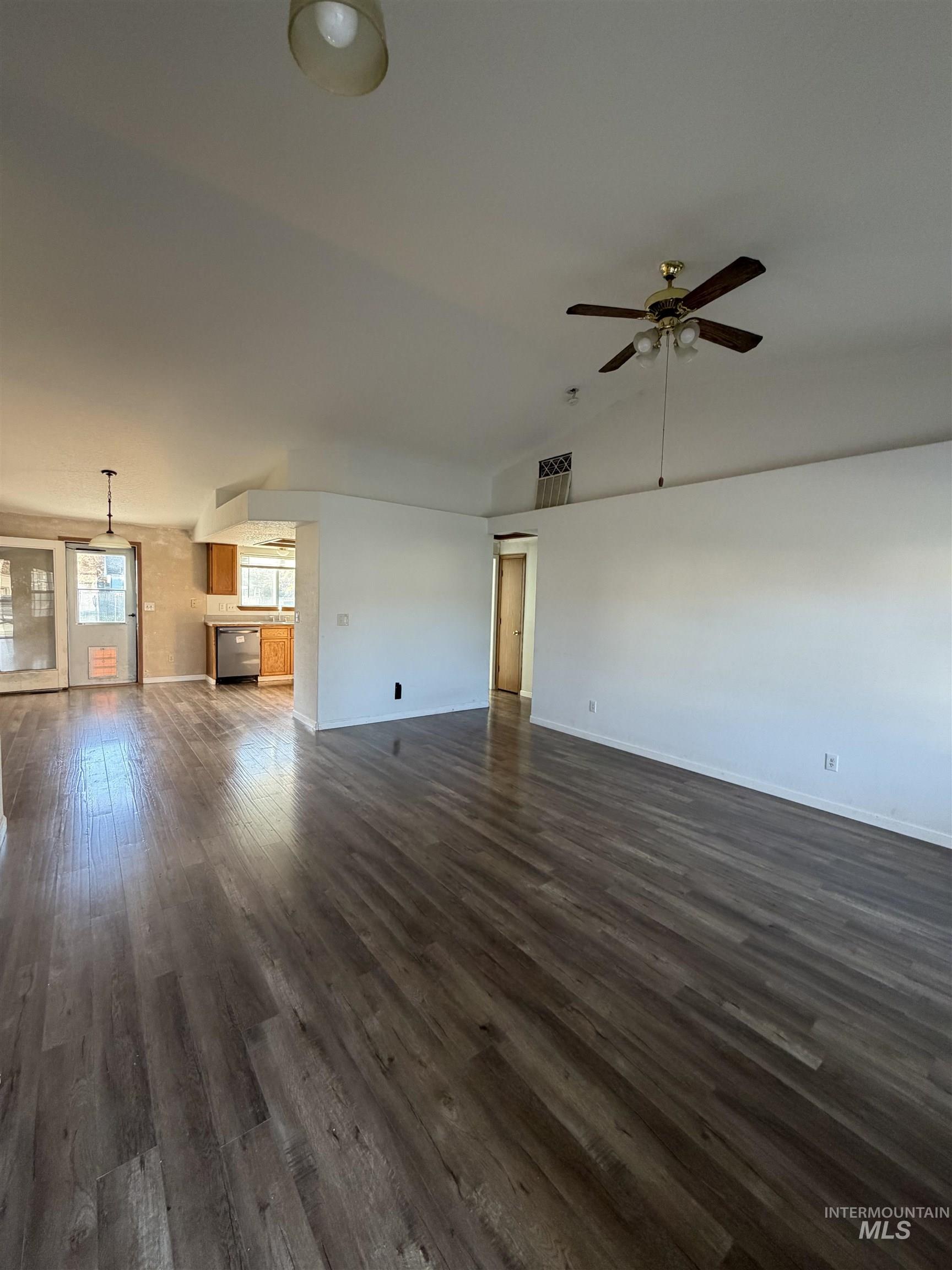 Unfurnished living room with dark wood finished floors and ceiling fan