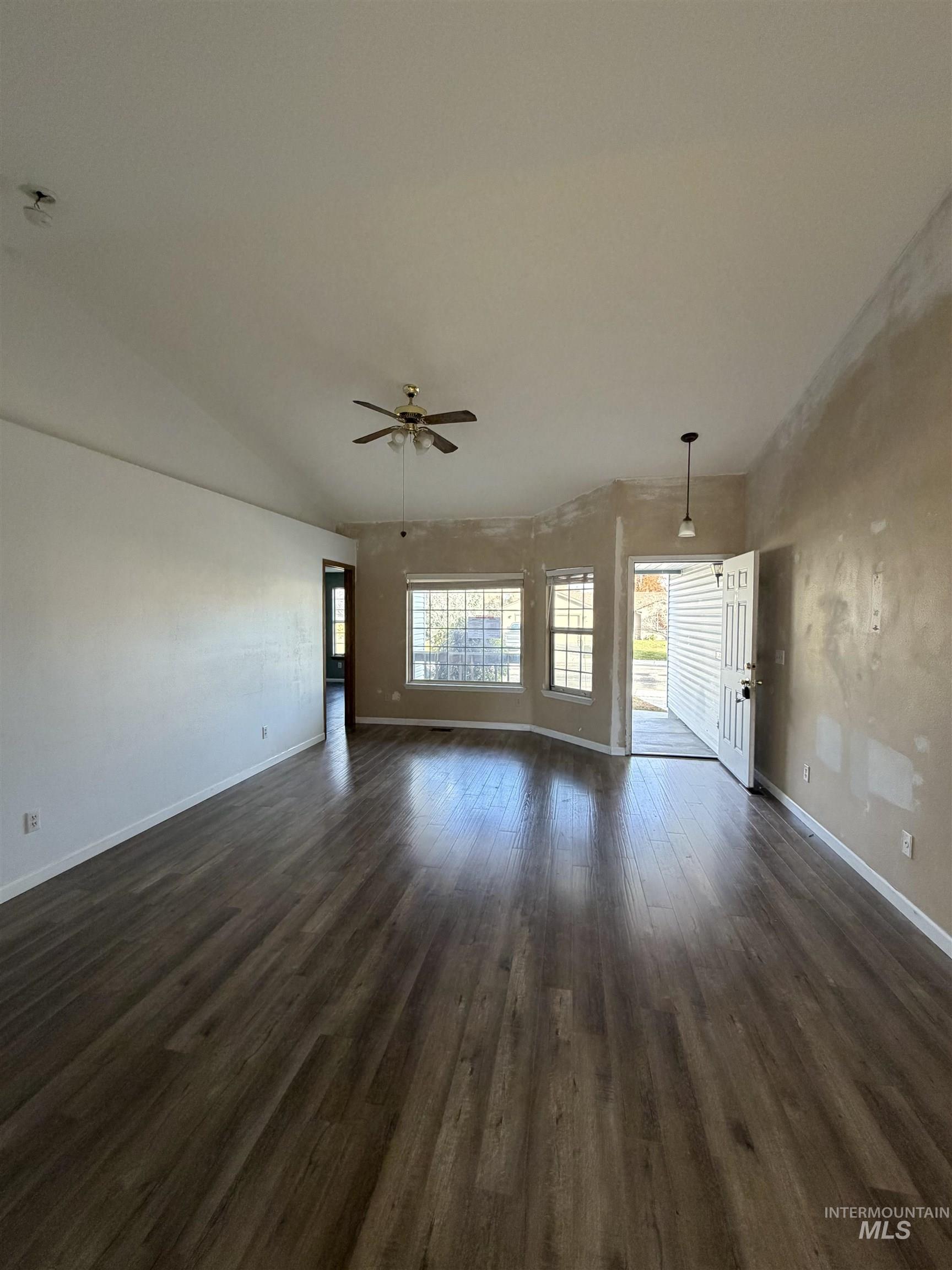 Unfurnished room with dark wood finished floors and ceiling fan