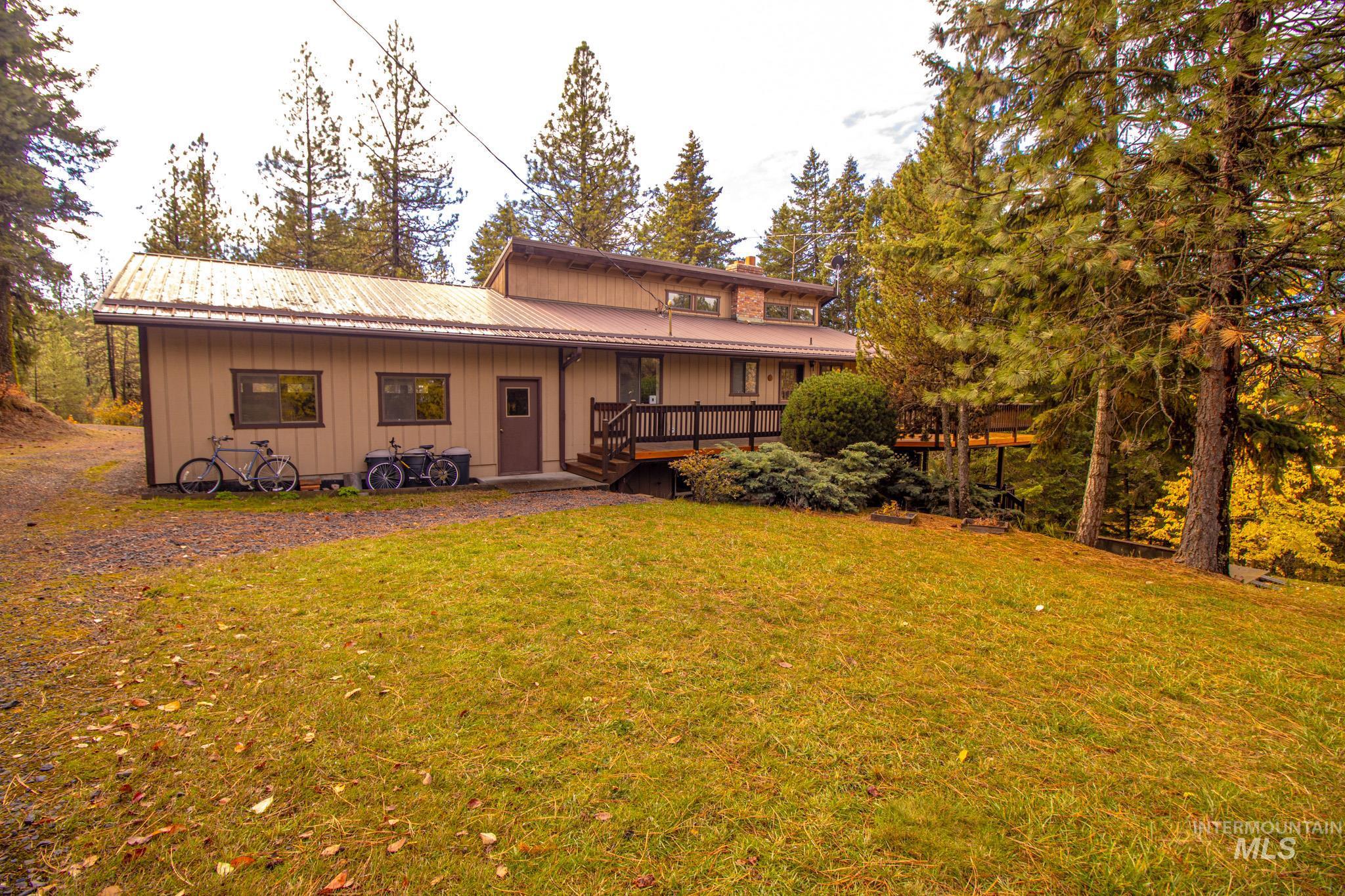 Rear view of house featuring a yard, a metal roof, and a porch
